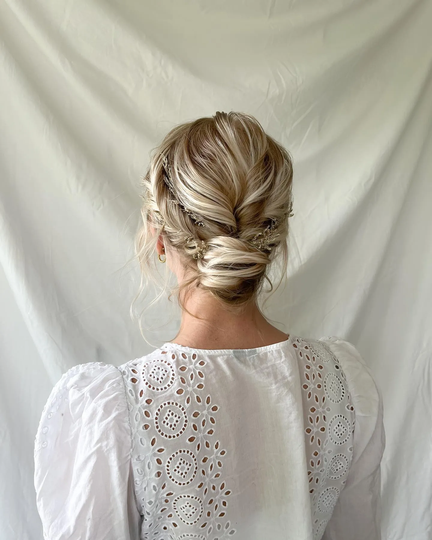 Wrapped low bun for short blonde hair with softly pinned sides