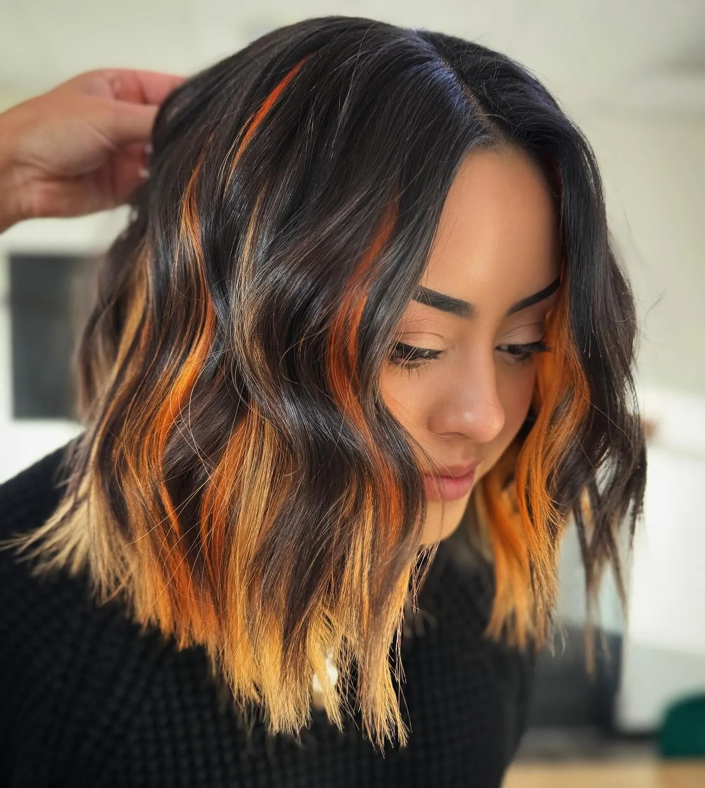 Dark bob with vivid orange ends and face-framing streaks
