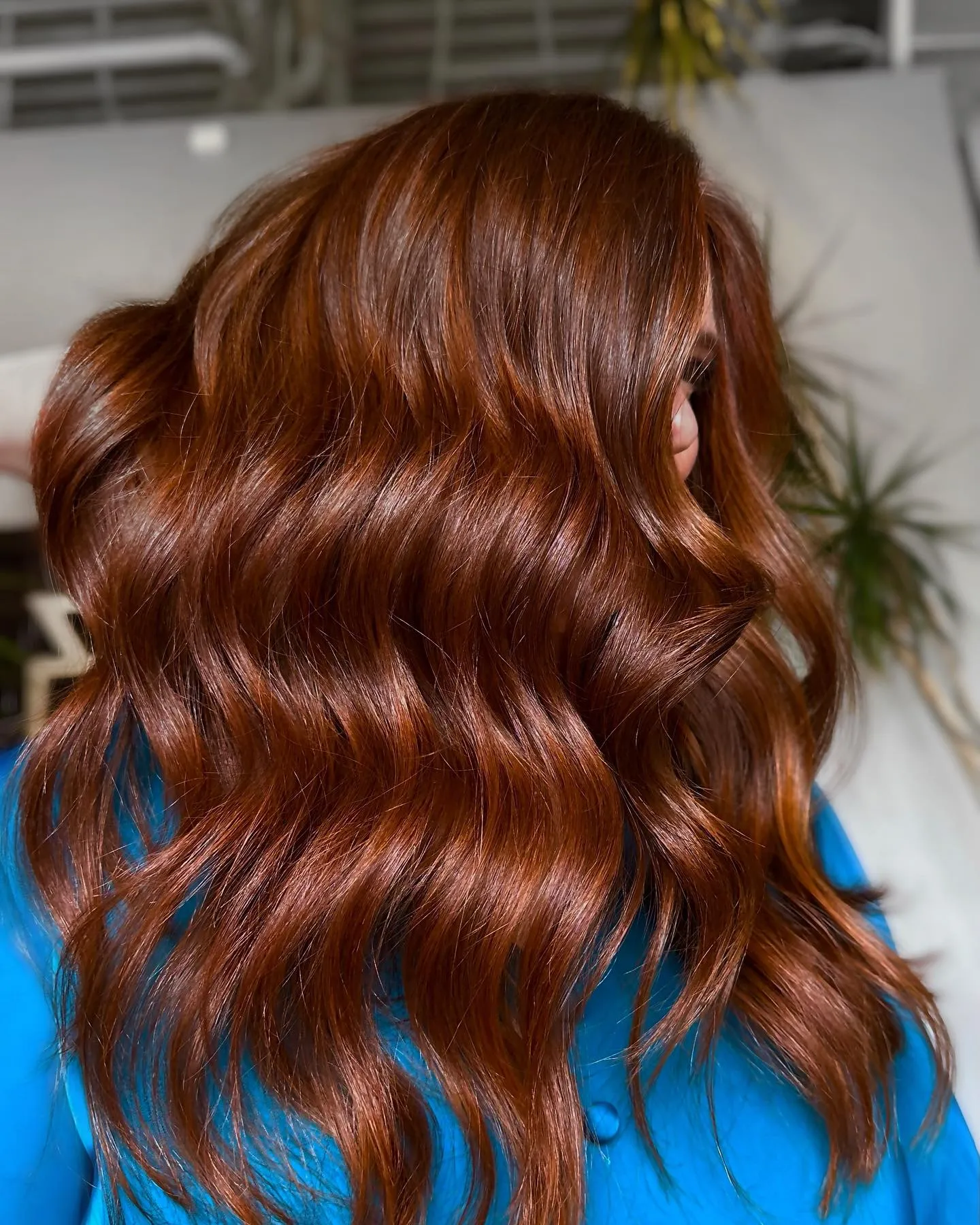 Glossy auburn waves on mid-length hair