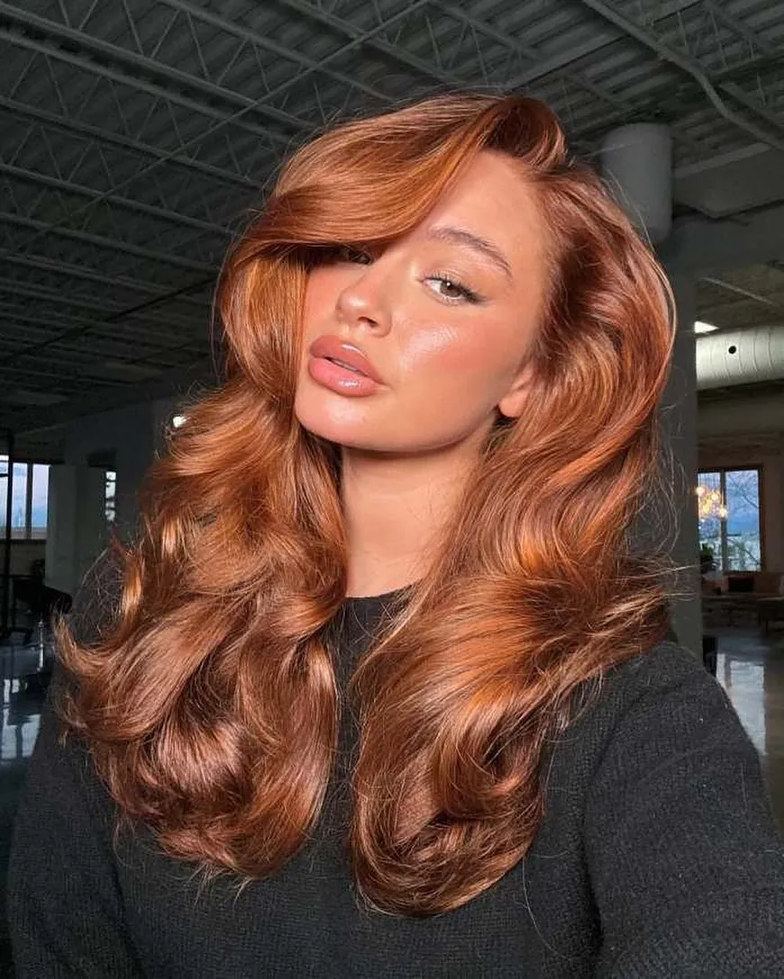 Long glossy copper waves with side-swept volume
