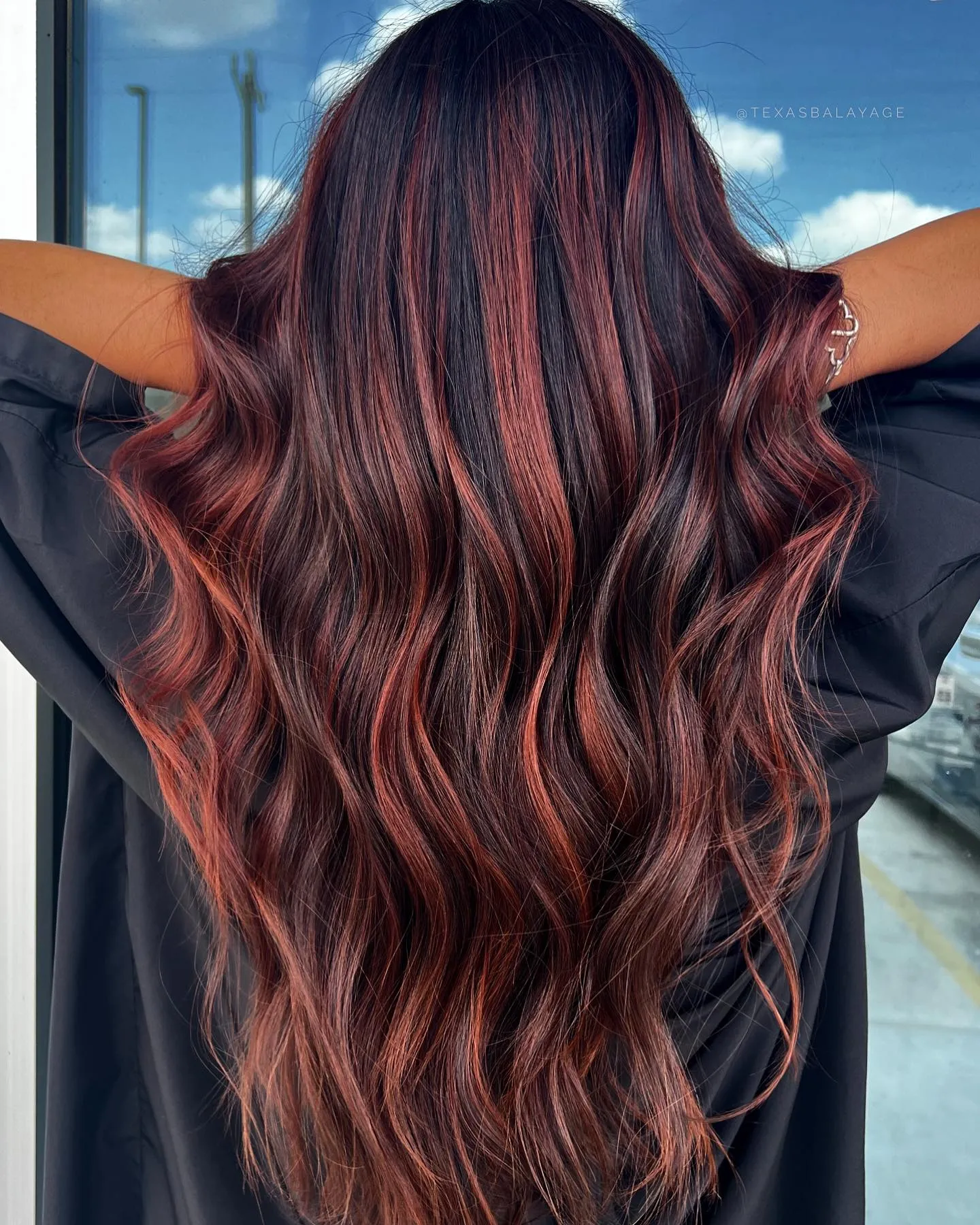 Dark wavy hair with fine red ribbon highlights