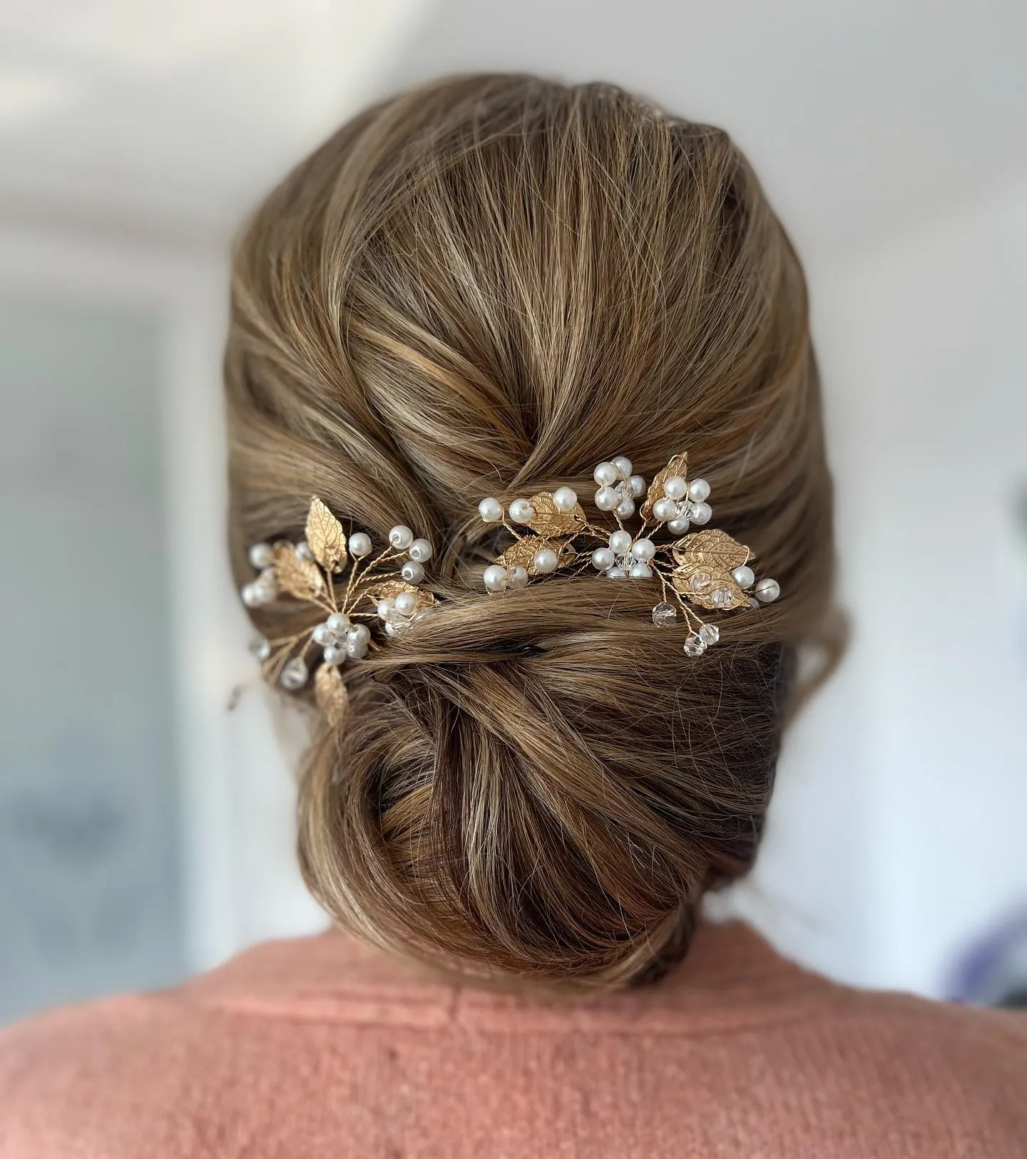 Low twisted bun with floral hair vine