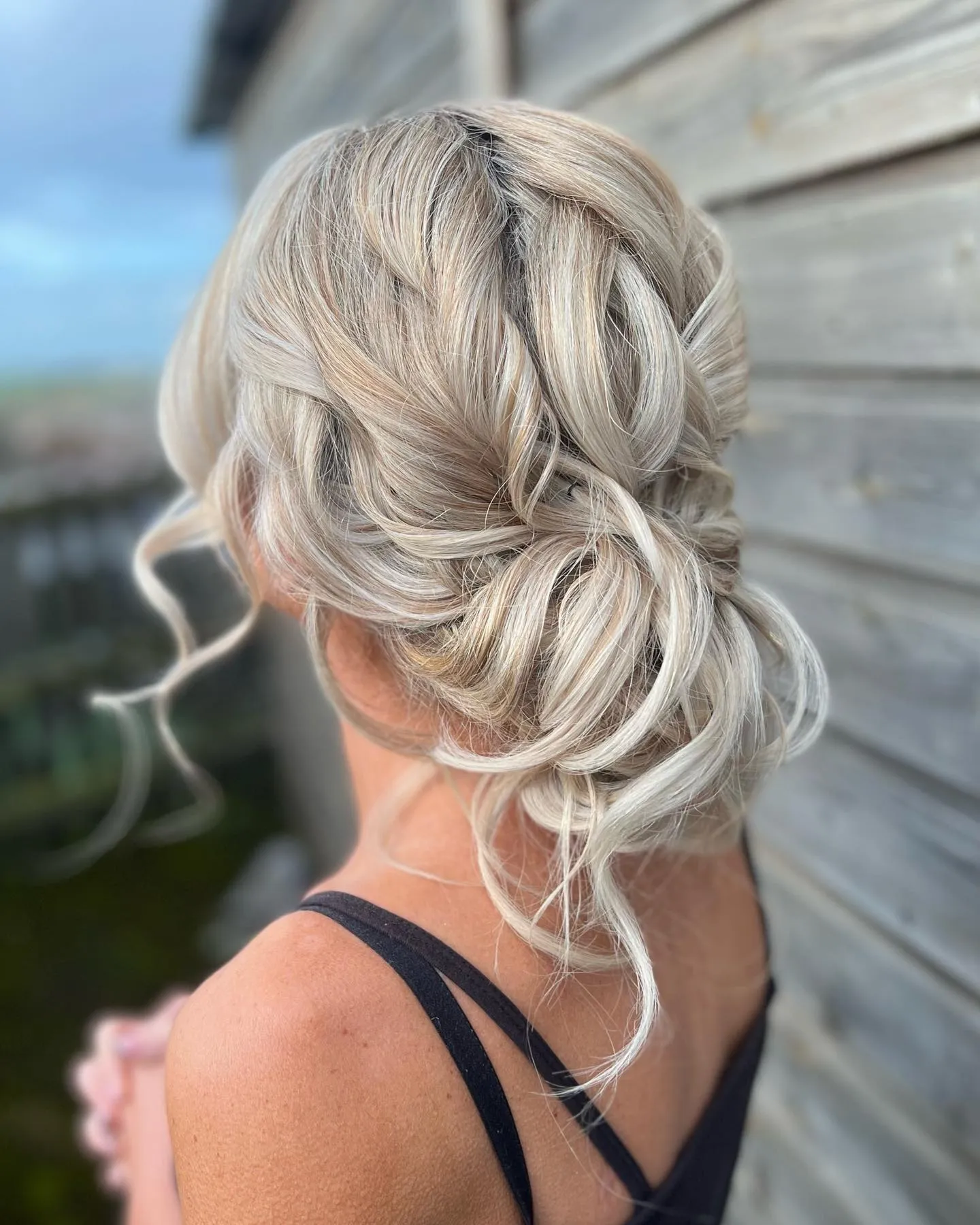 Soft textured bun with face-framing tendrils