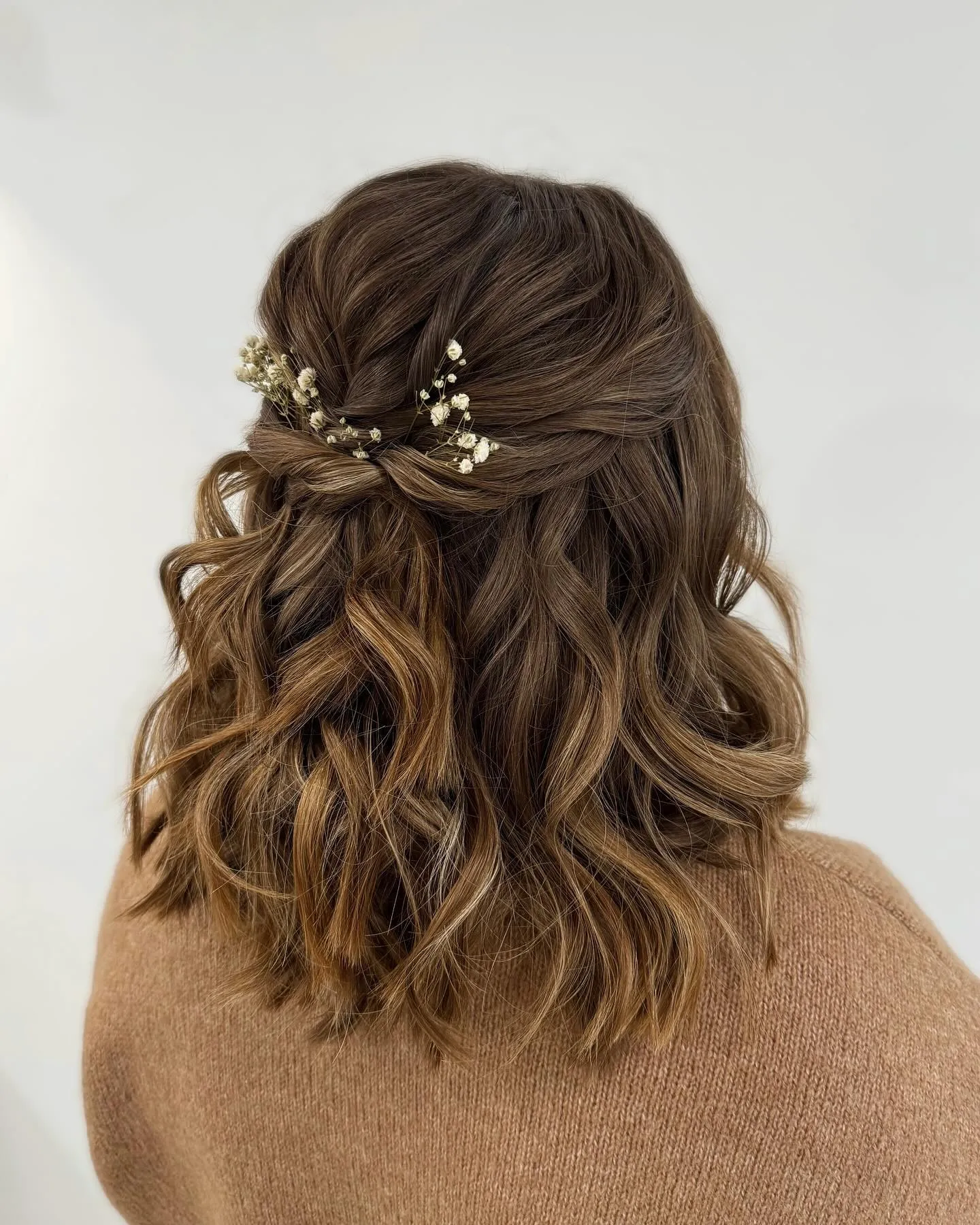 Twisted half-up waves with floral sprigs