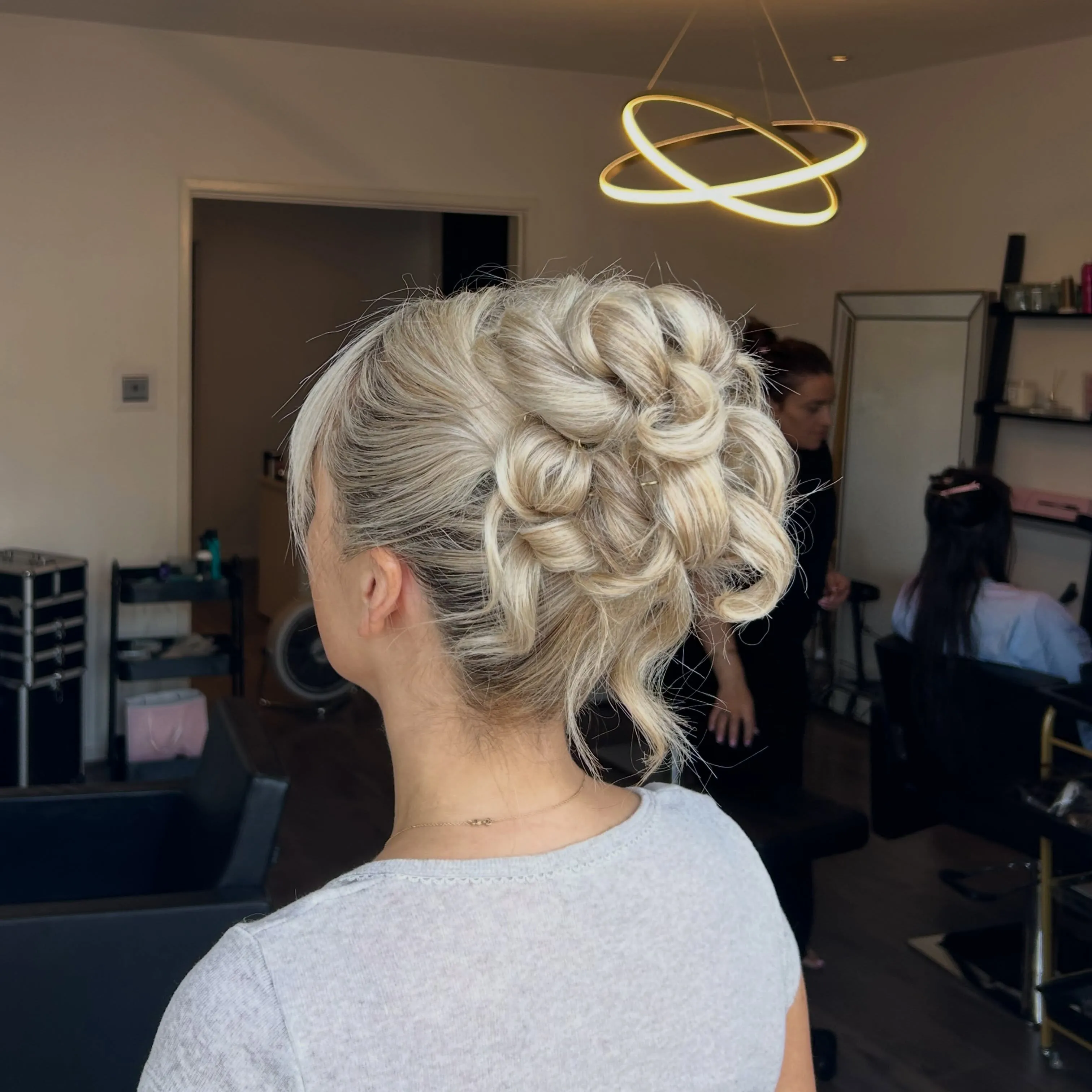 Short curled hair pinned into a full updo