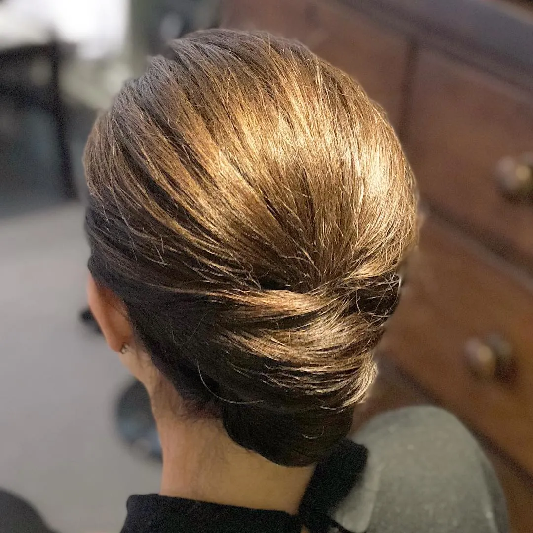 Smooth short hair rolled into a low updo