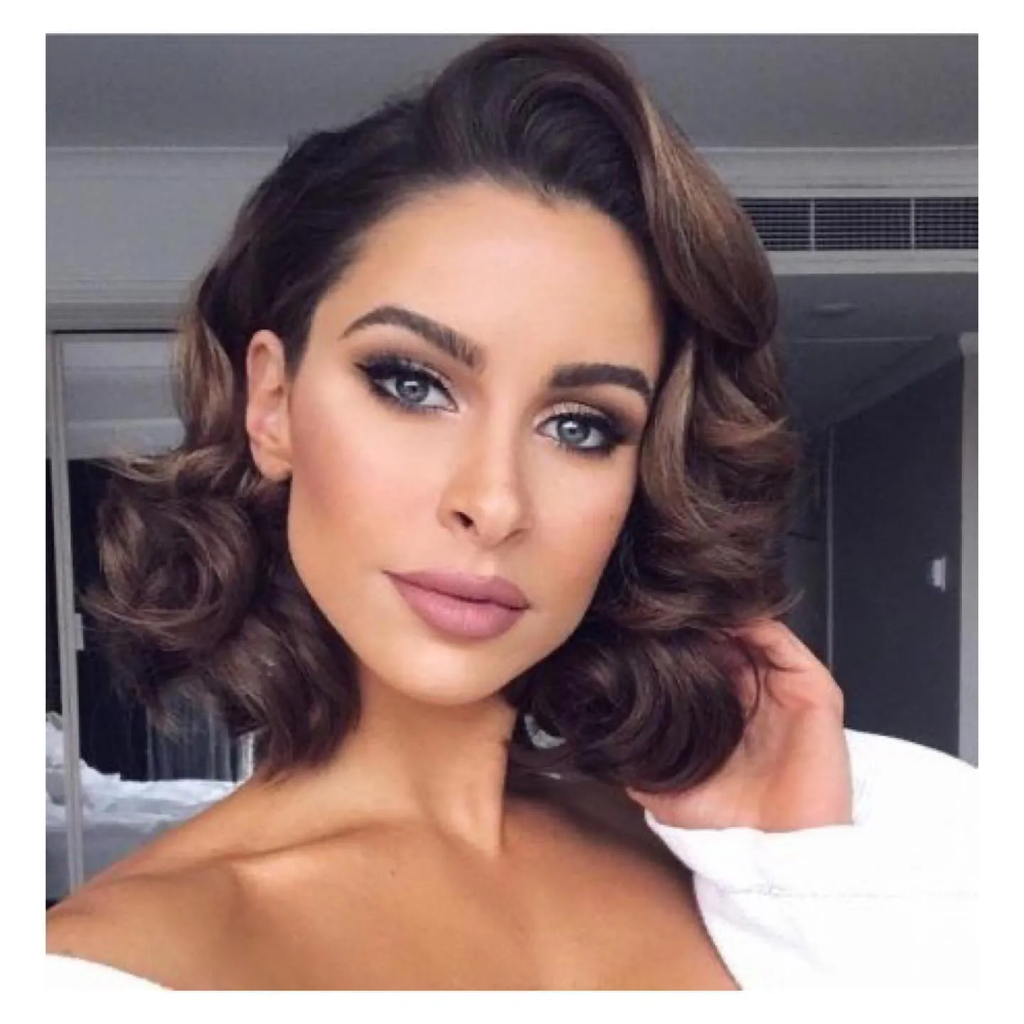 Short dark hair styled in vintage side-swept waves