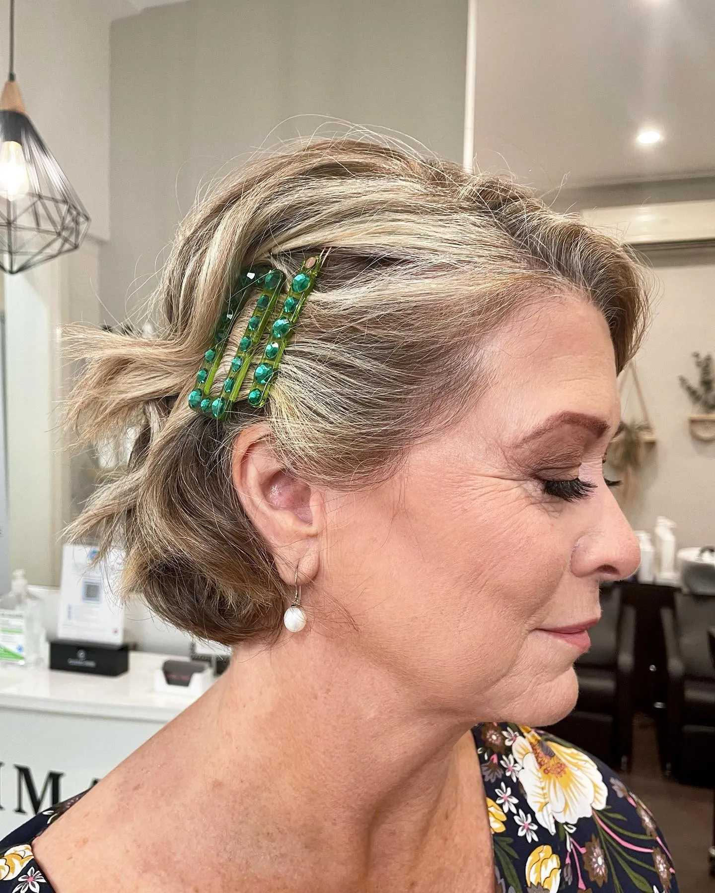 Short curled bob pinned with decorative green clips