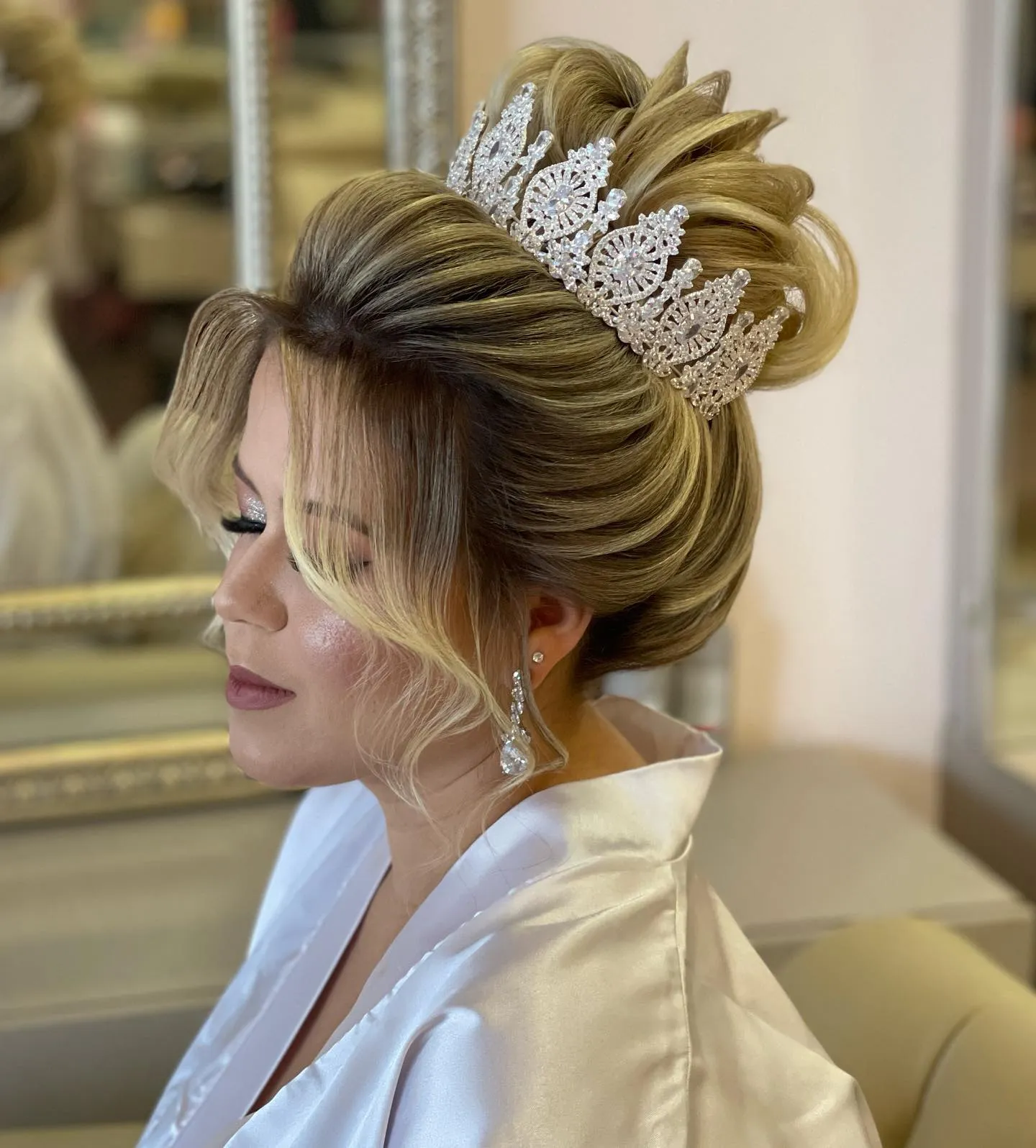 Smooth high bridal bun with a lace-style crown