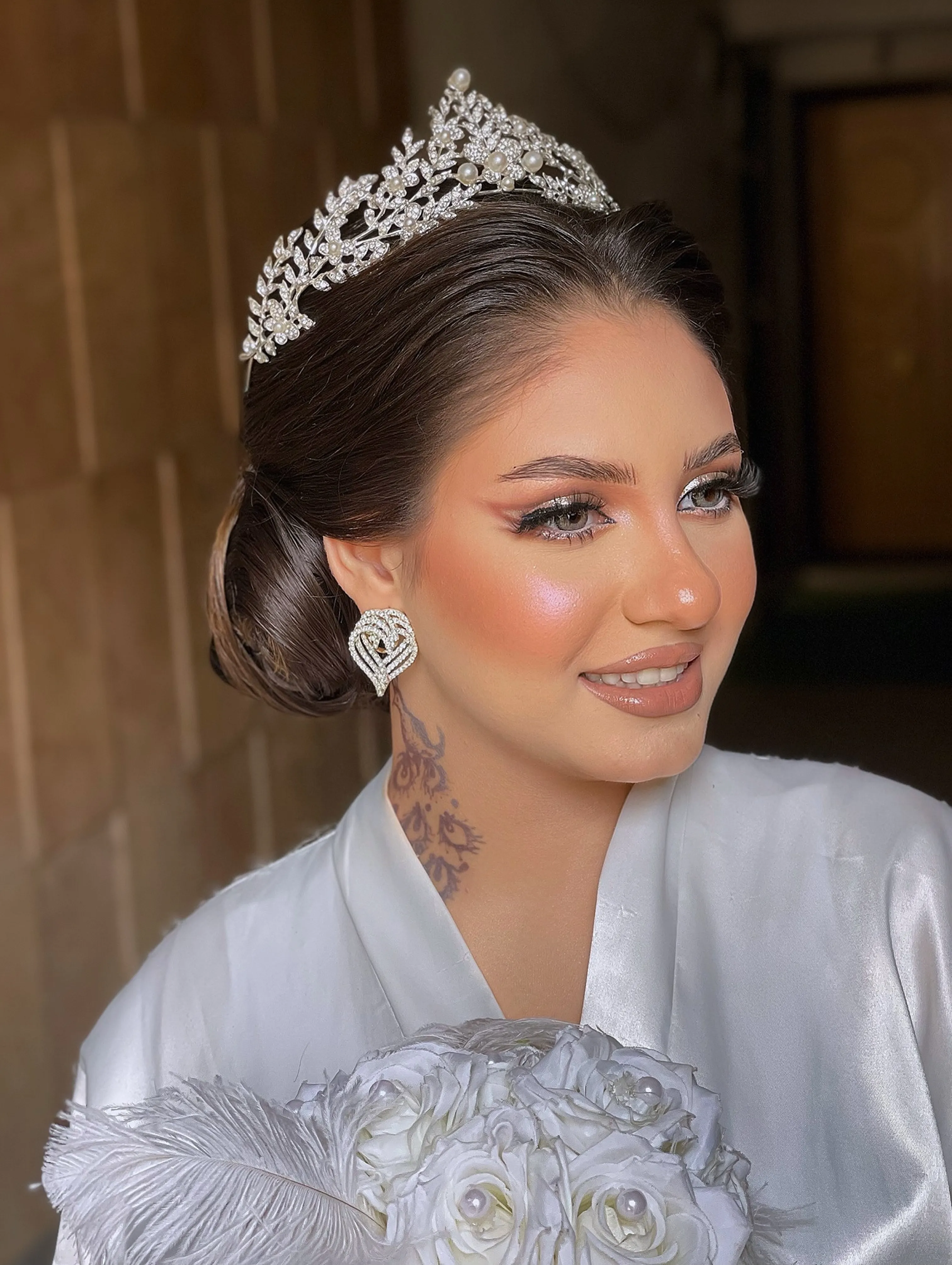 Sleek low bridal bun with a silver tiara