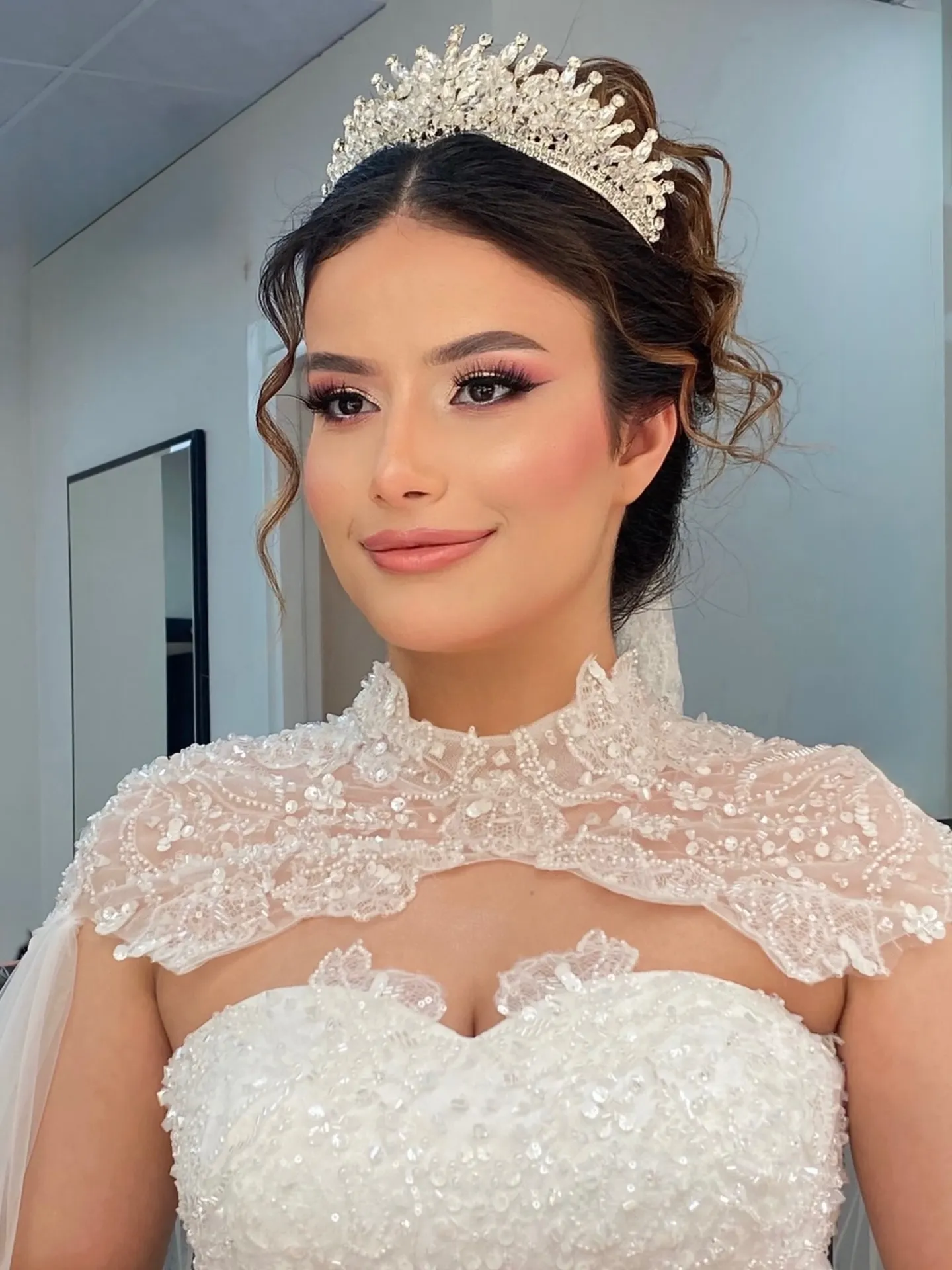 Soft low updo with a tall gold bridal crown