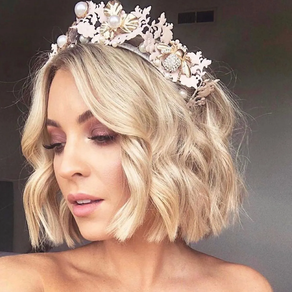 Short blonde wavy bob with a floral bridal crown