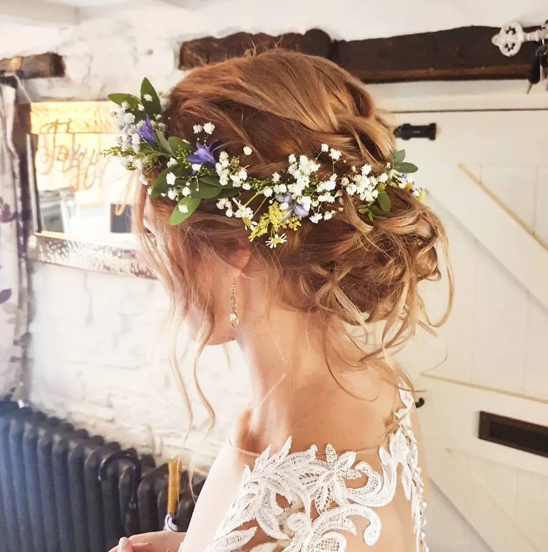 Loose low bridal updo with a delicate white flower crown