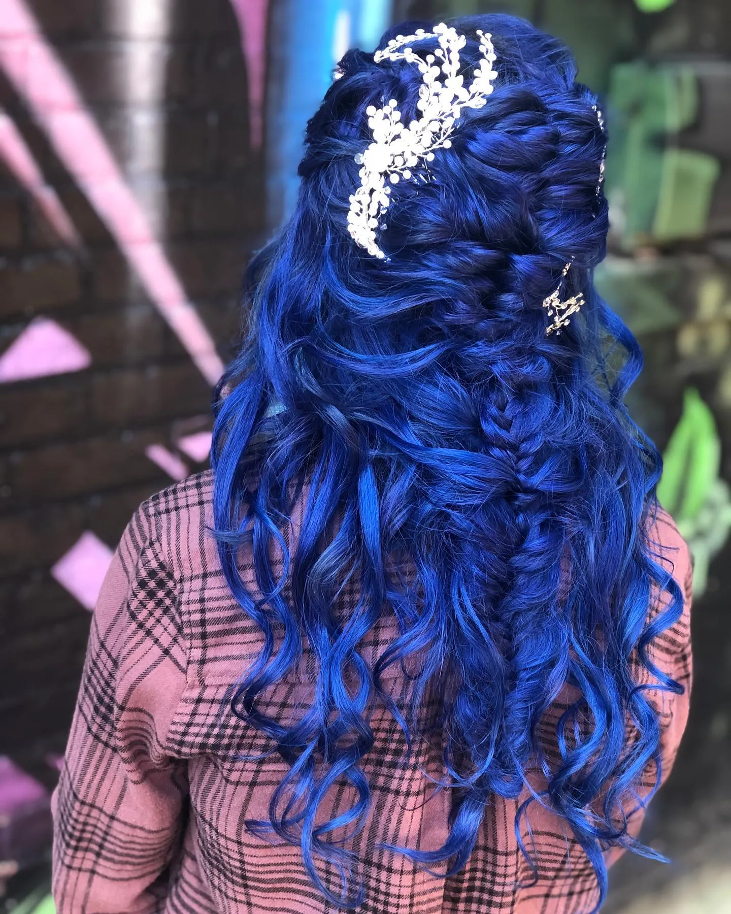 Blue braided half-up curls with a crystal botanical hairpiece