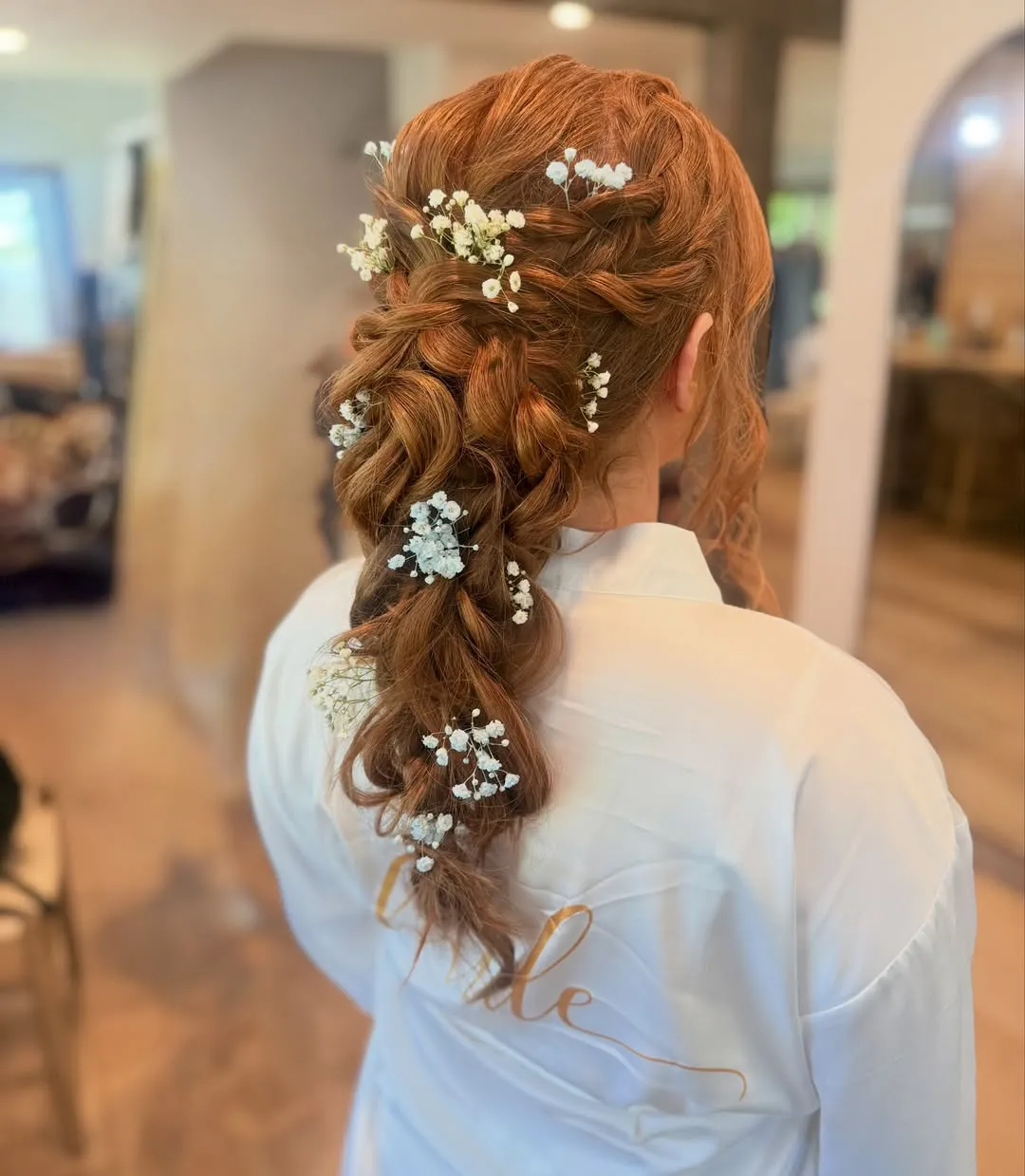 Twisted low bridal ponytail with baby's breath flowers