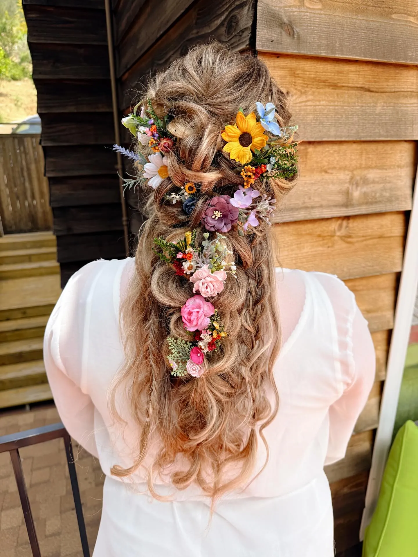 Long half-up bridal waves with a colourful floral cascade