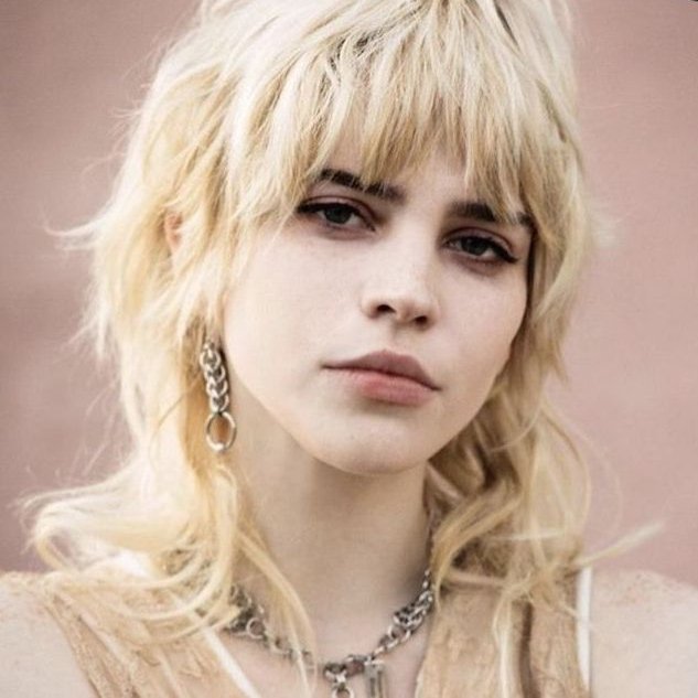 Long blonde wolf cut with full fringe and feathered lengths