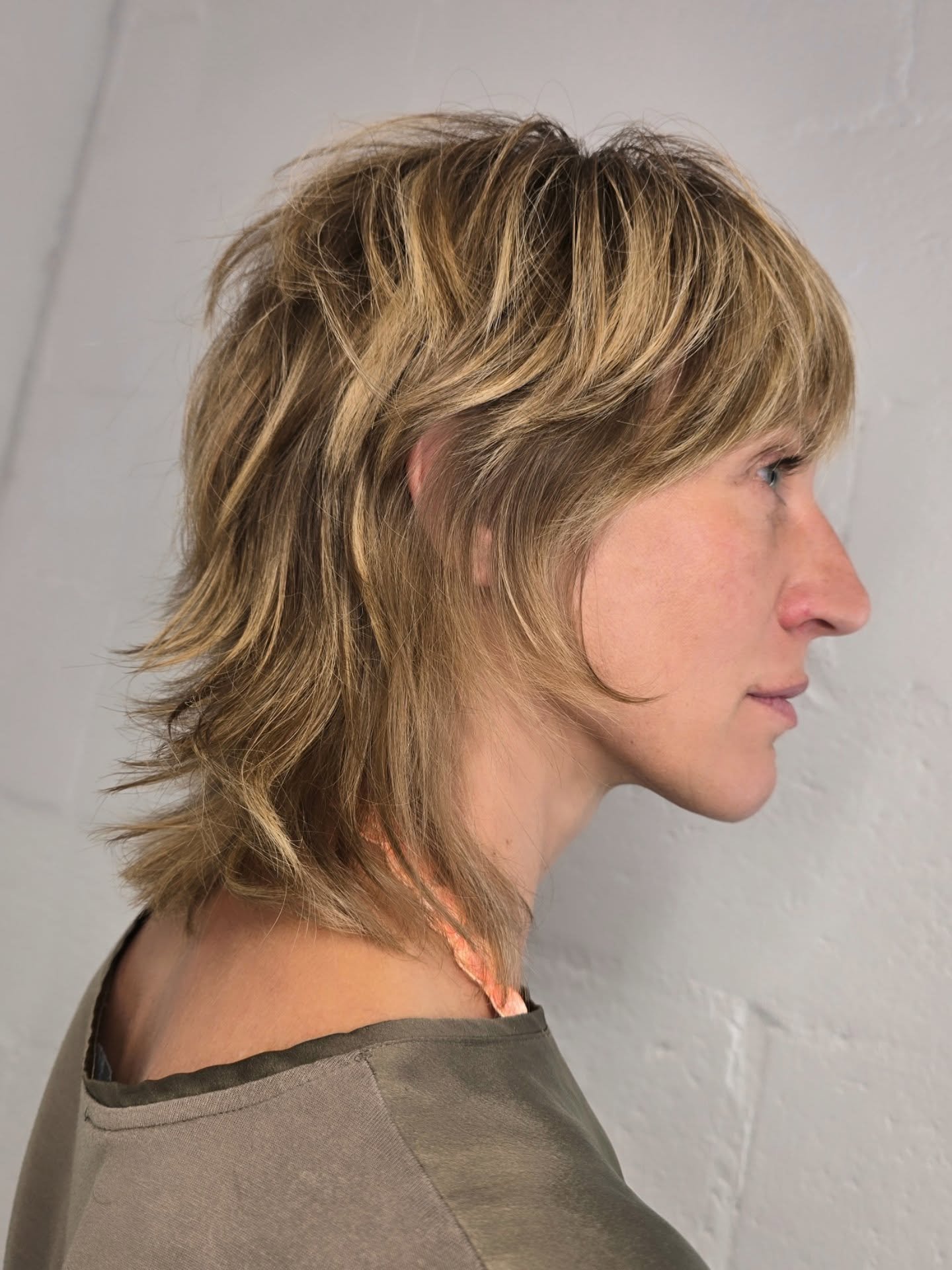 Highlighted wolf cut with side-swept fringe and sharply flipped ends