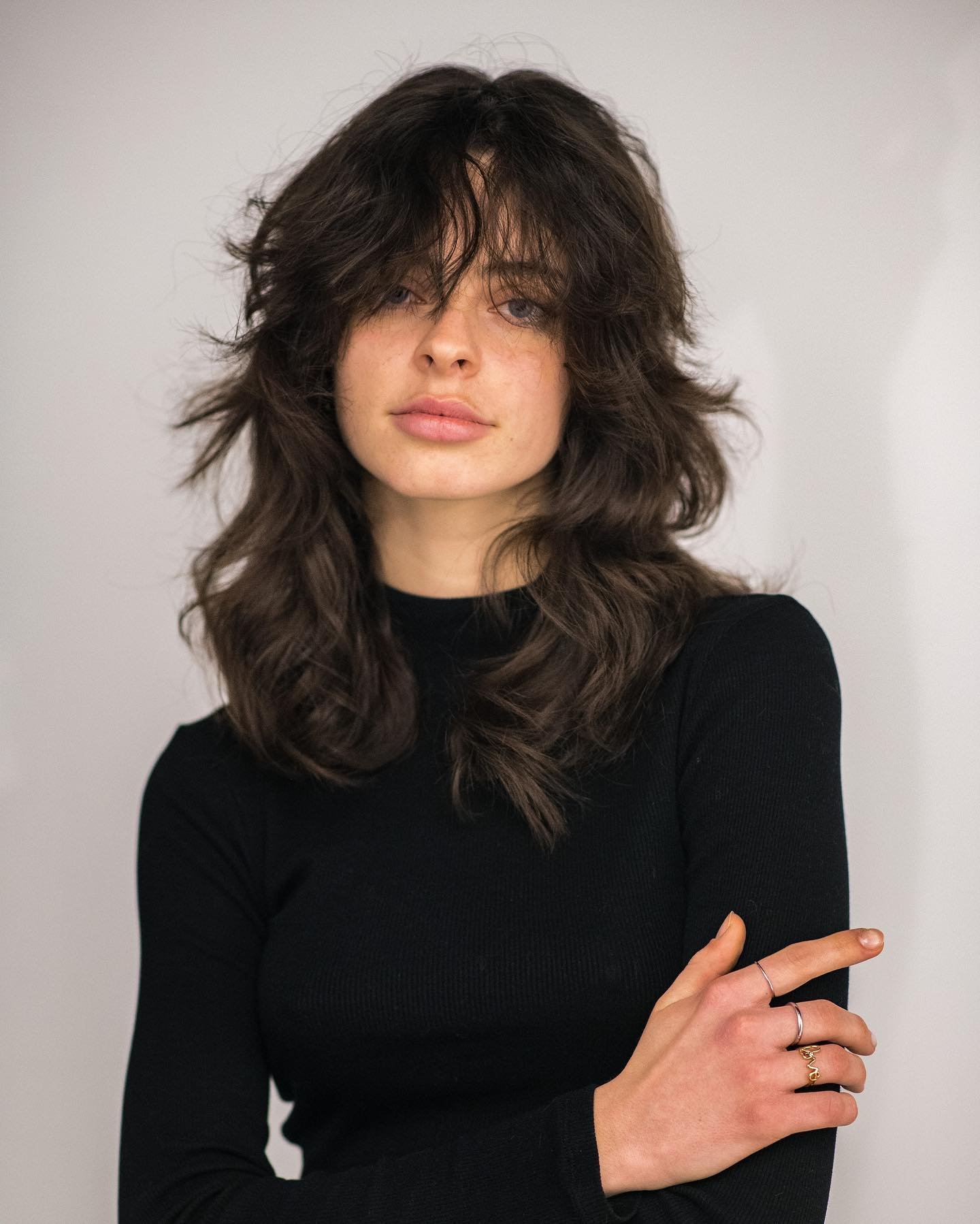 Long voluminous wolf cut with shaggy fringe and flipped layers