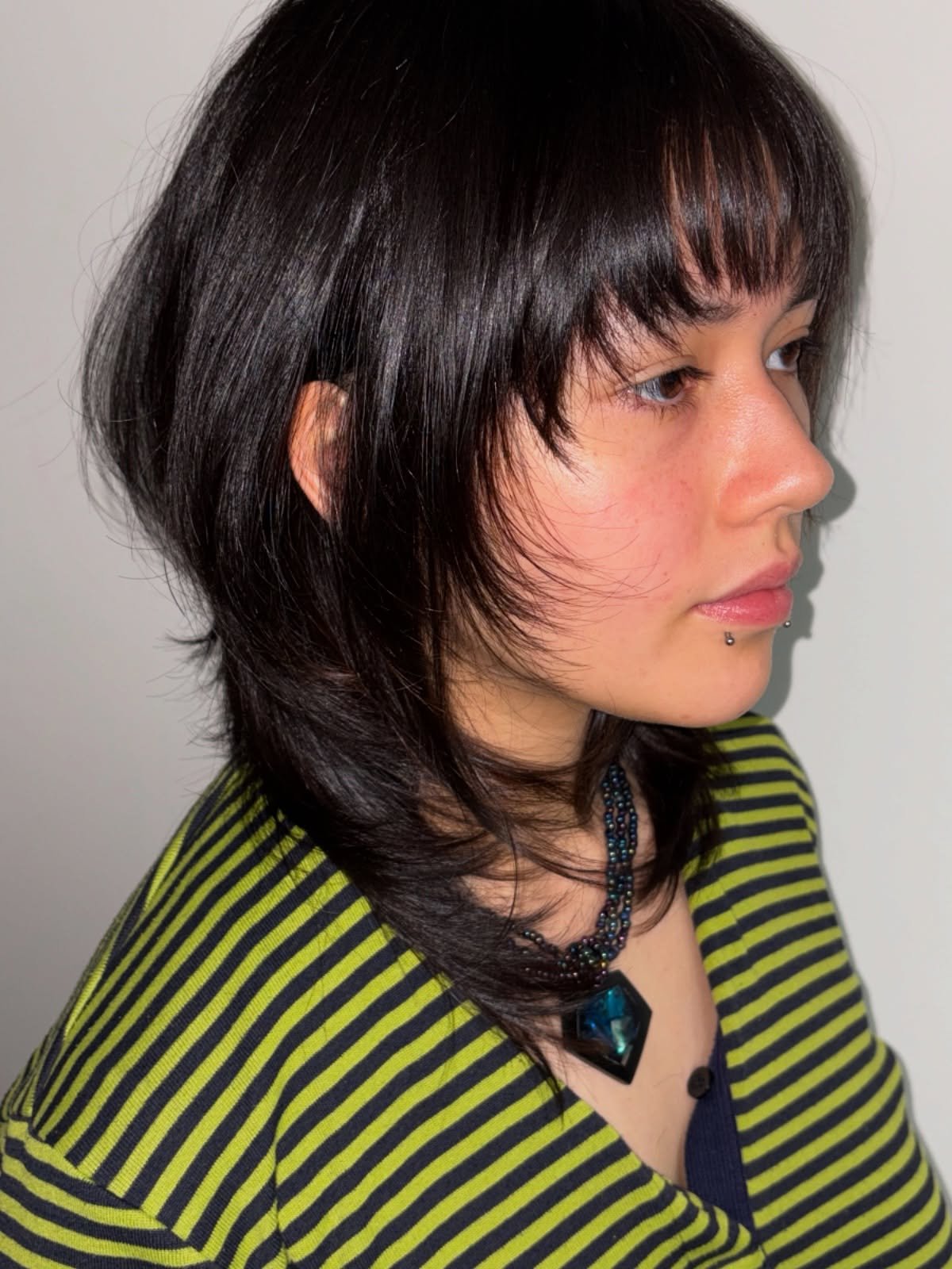Sleek dark wolf cut with short blunt fringe and tapered layers
