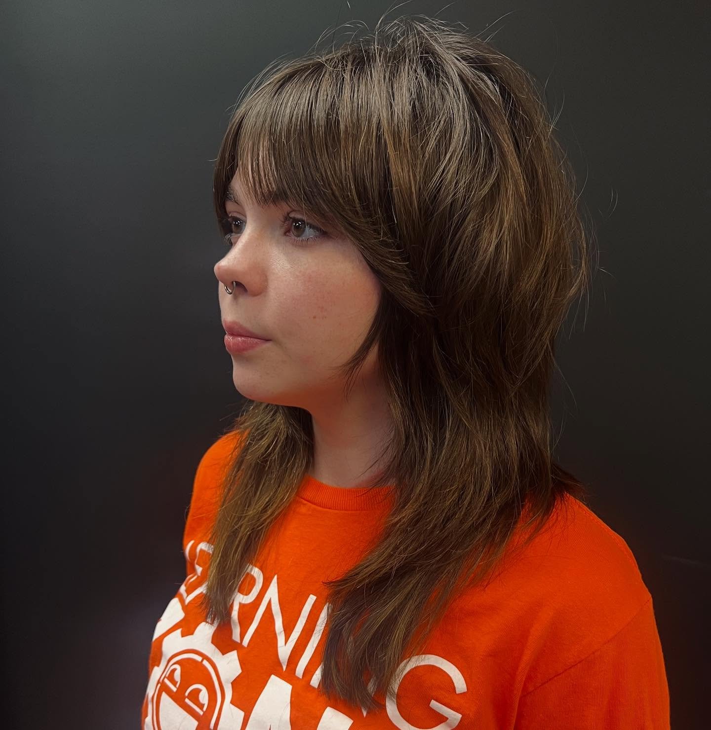 Soft shoulder-length wolf cut with wispy bangs and textured layers