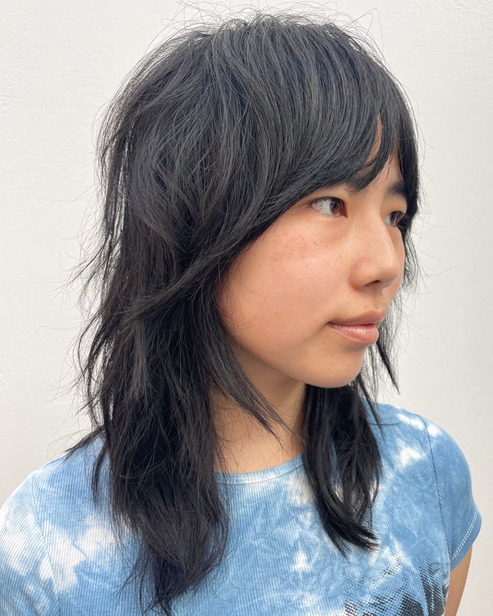 Long straight wolf cut with side fringe and feathered face-framing layers