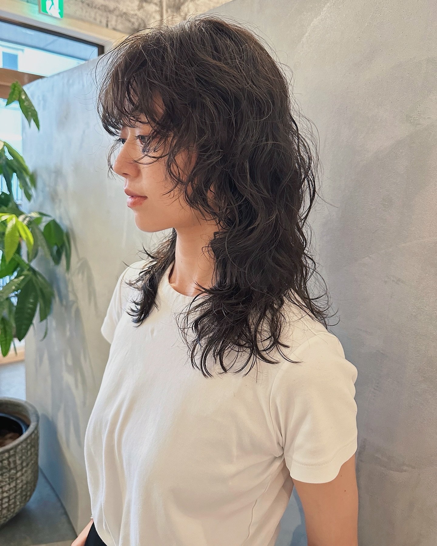 Curly wolf cut with rounded fringe and long layered curls