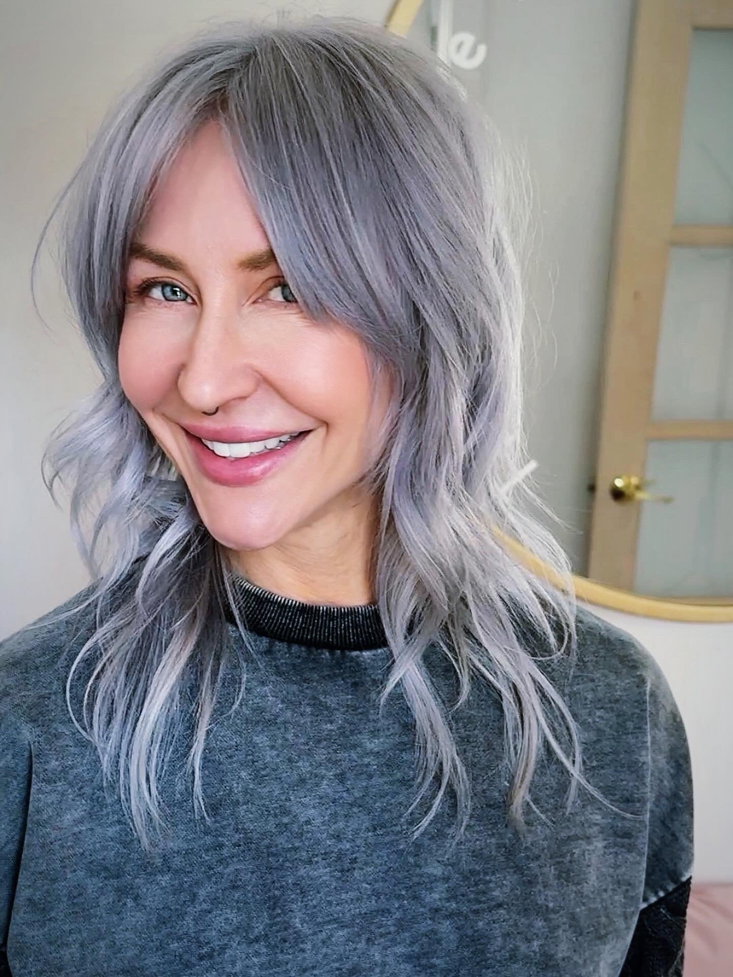 Silver wolf cut with soft curtain bangs and loose layered waves
