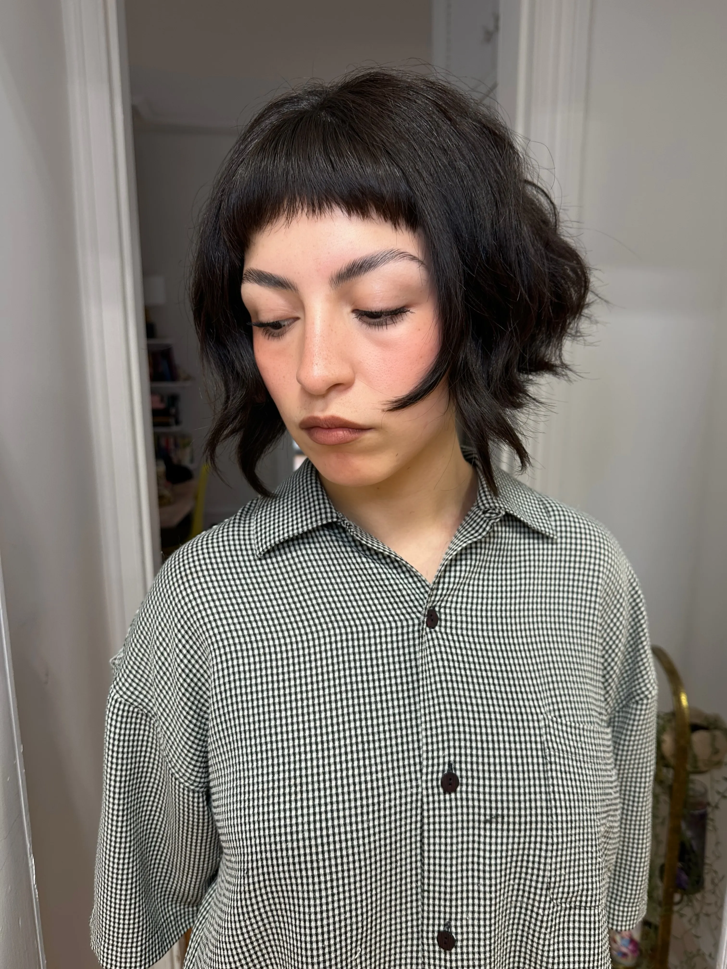 Short black bob with micro fringe and outward-flipped sides