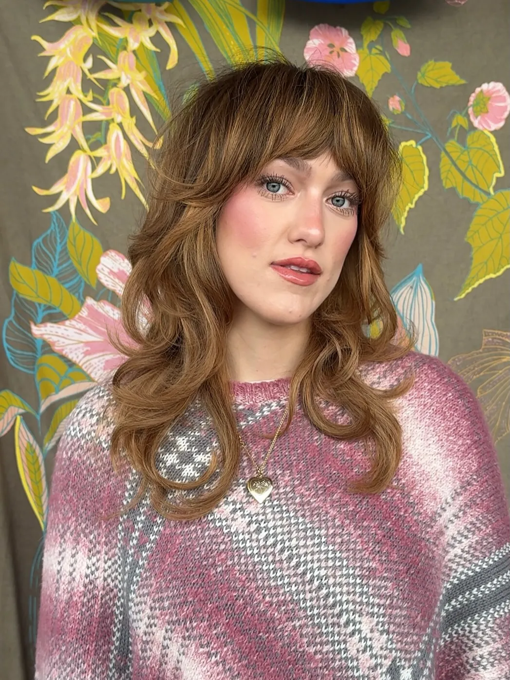 Long layered haircut with full fringe and feathered curled-out ends