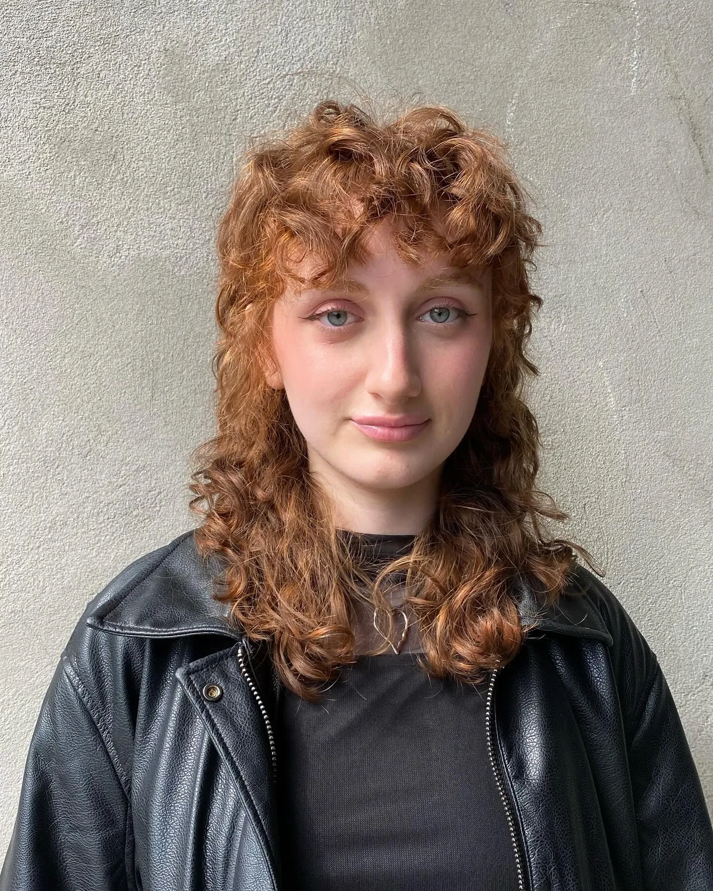 Curly shag haircut with short fringe and longer flared curls