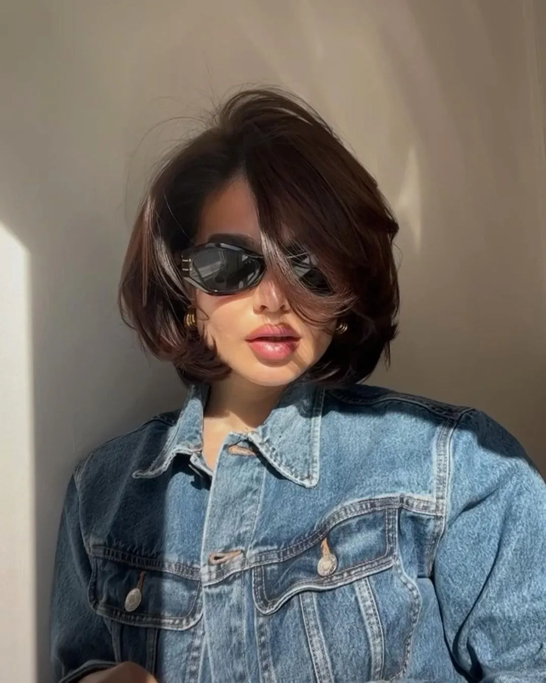 Short dark bob with side part and pronounced winged ends