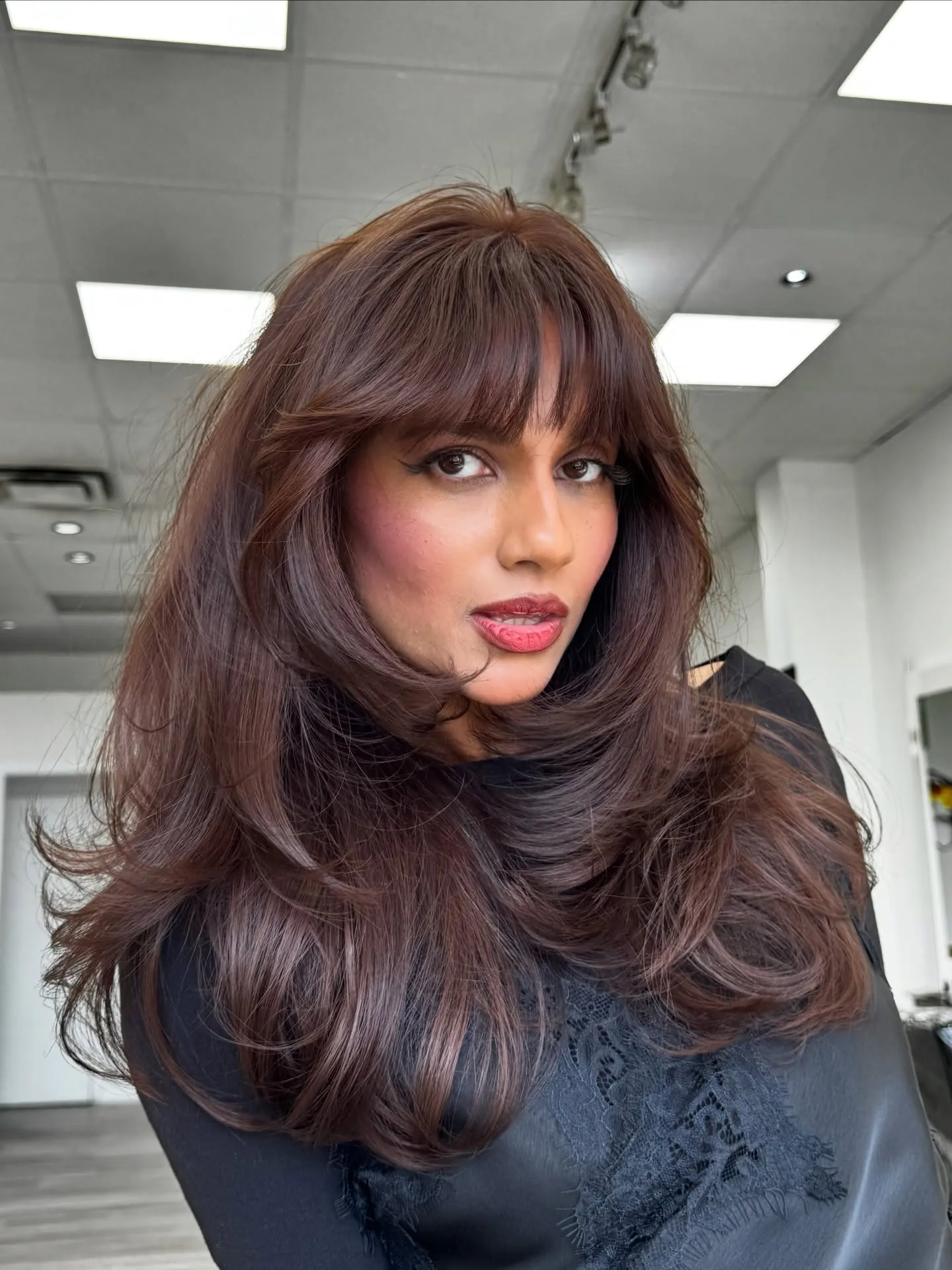 Voluminous layered hair with full Birkin fringe