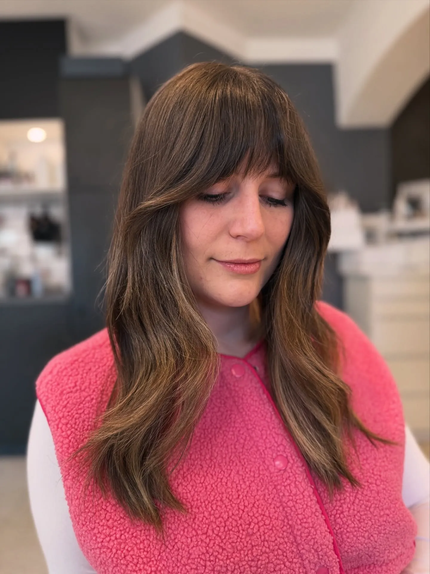 Layered brunette hair with soft Birkin bangs