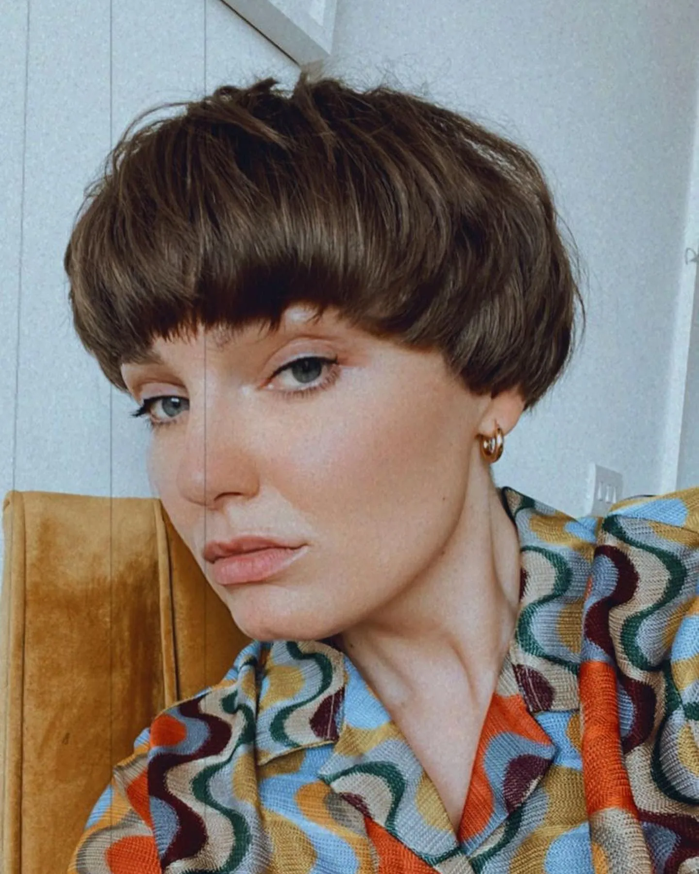 Short piecey brown bowl cut with cropped fringe