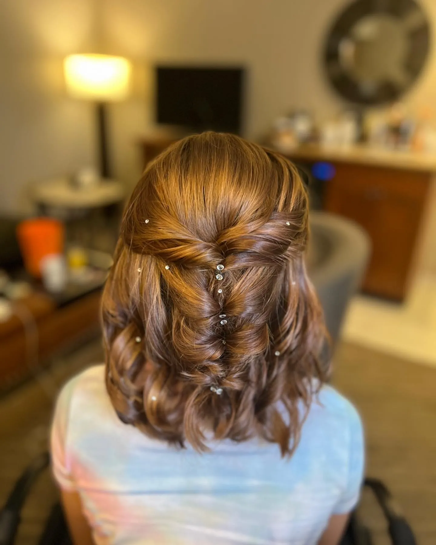 Curled short bob with a pearl-pinned half-up twist
