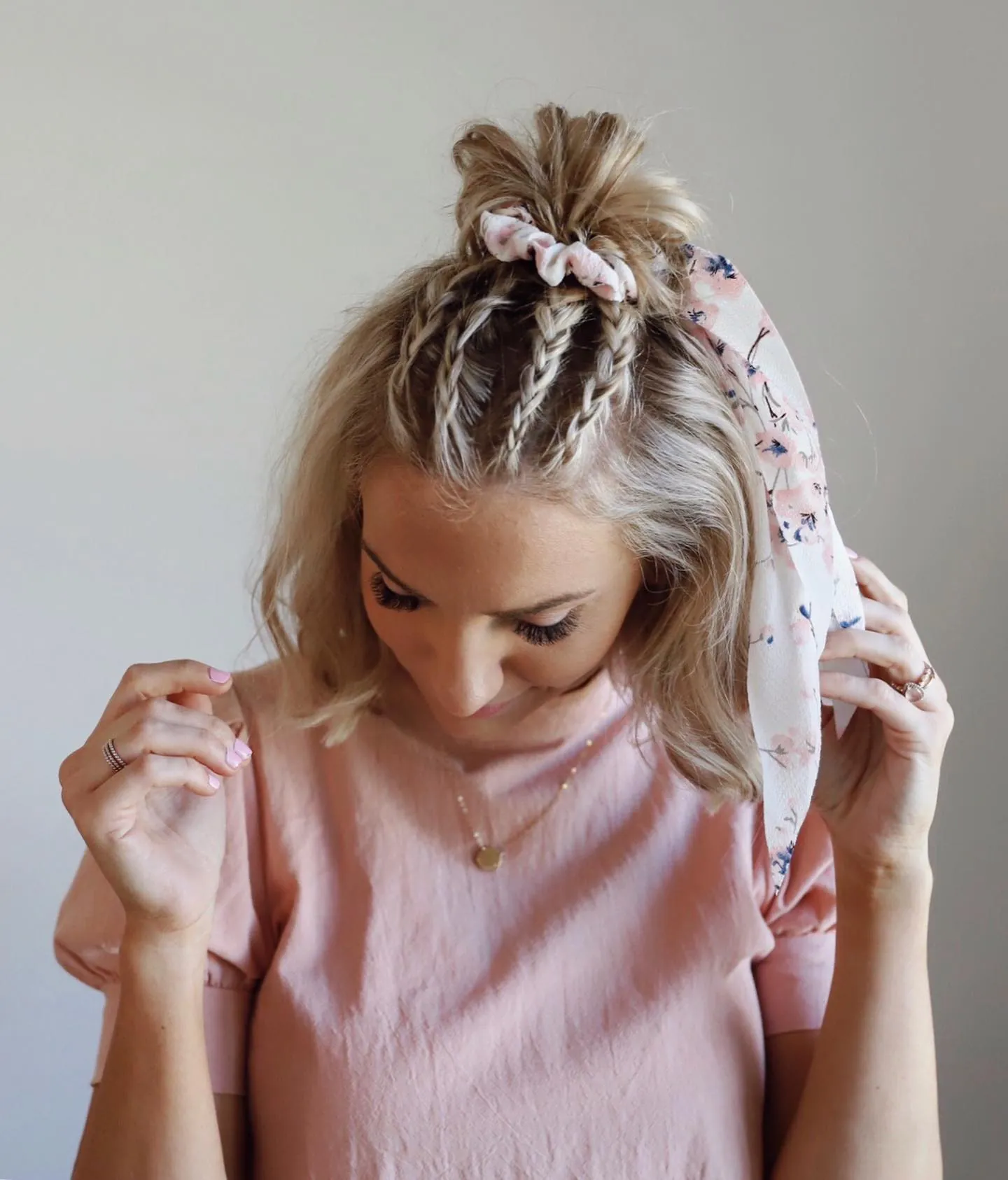 Short blonde bob with small top braids and a mini ponytail