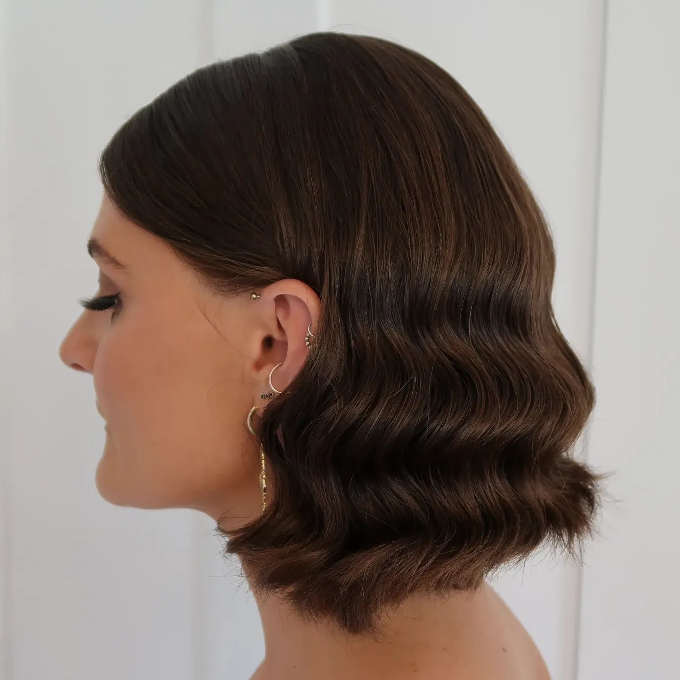 Glossy brunette bob styled in S-shaped waves