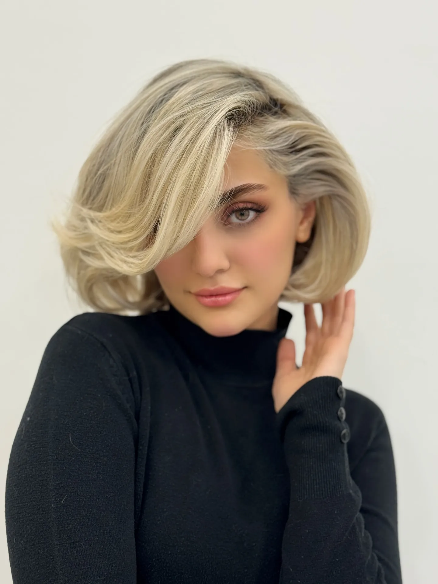 Blonde bubble bob with deep side part and rounded volume
