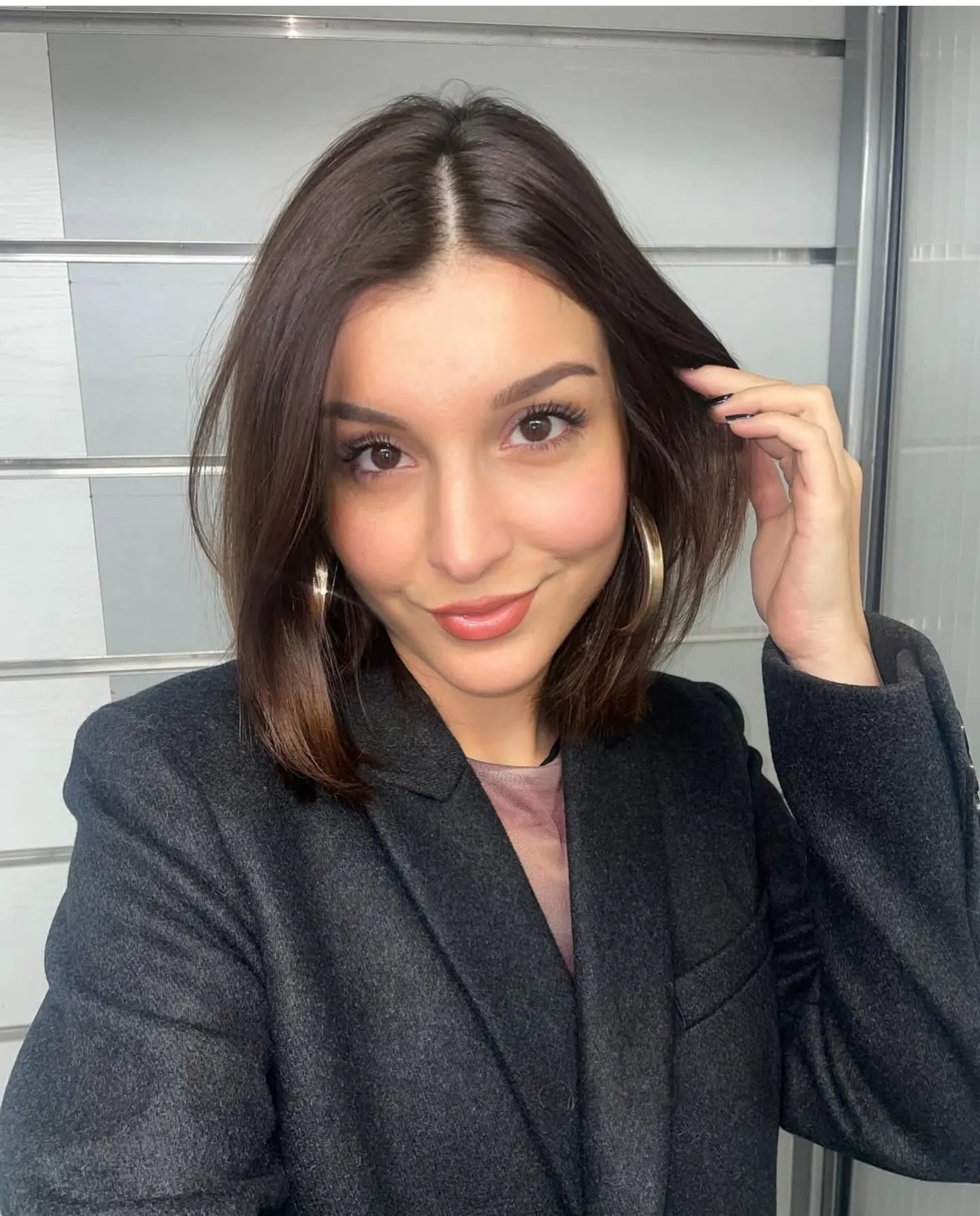 Short charcoal brunette lob with center part and softly curved ends