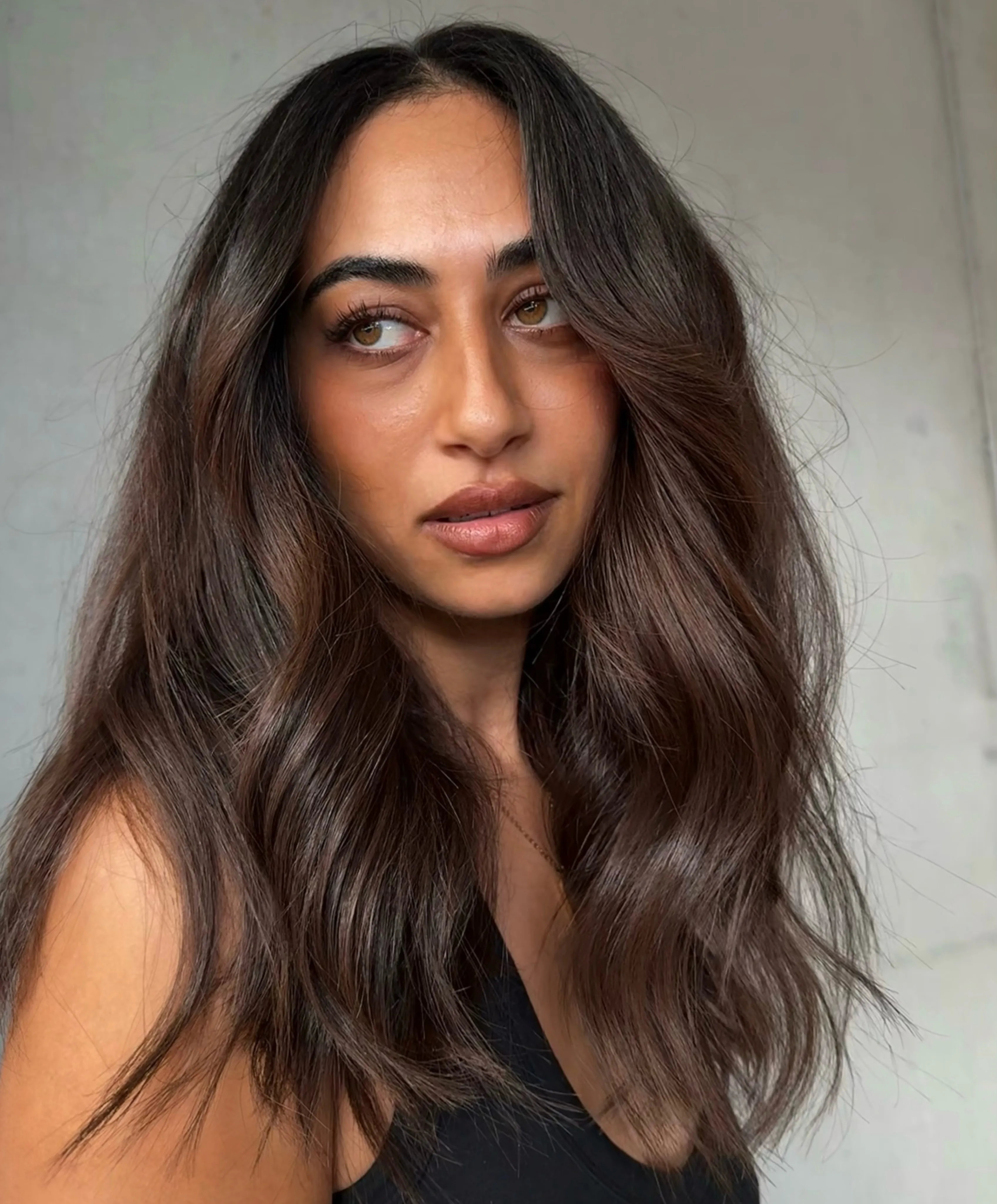Mocha-charcoal brunette hair with soft waves and face-framing pieces