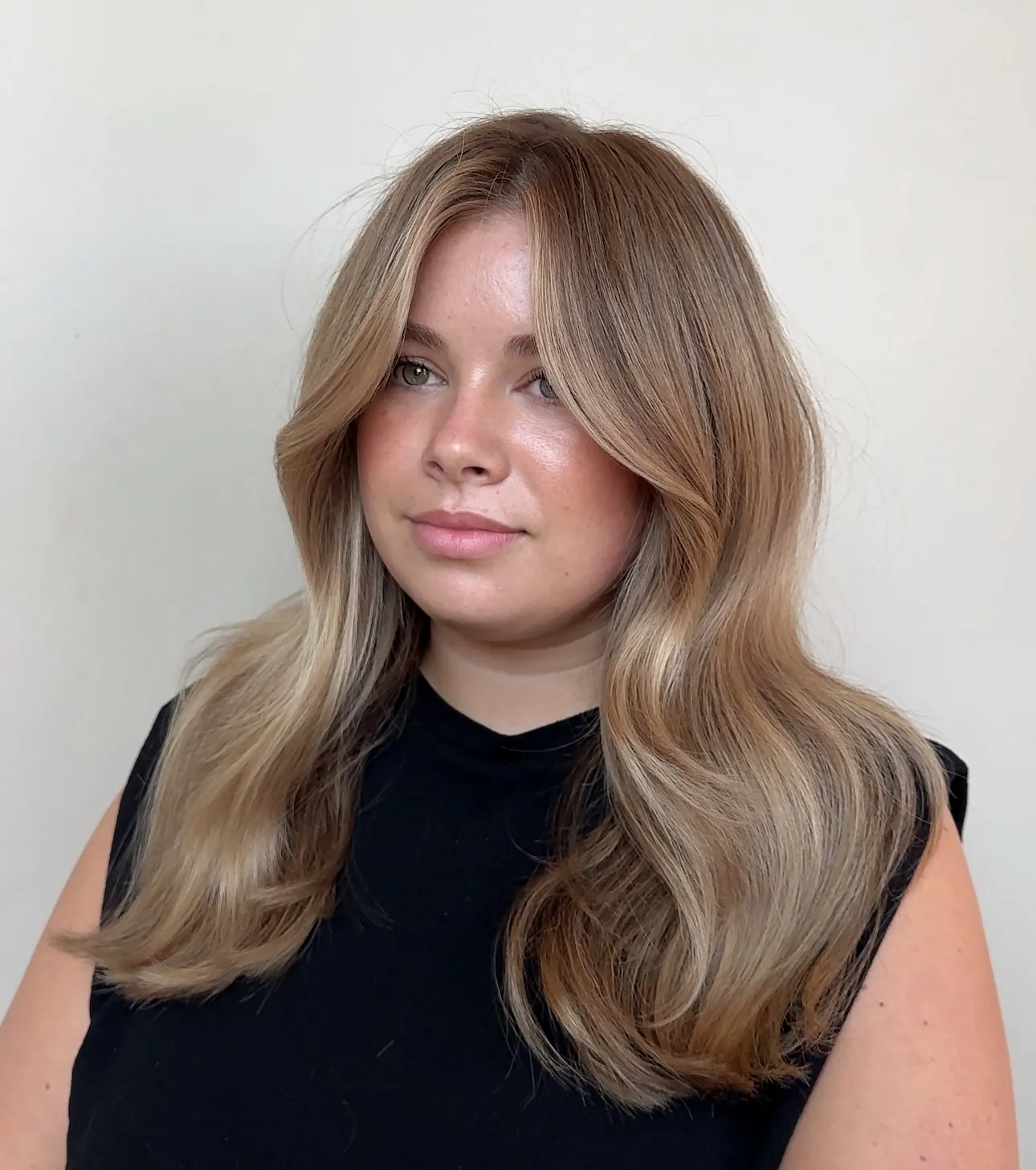 Rounded shoulder length blowout with neutral blonde tones