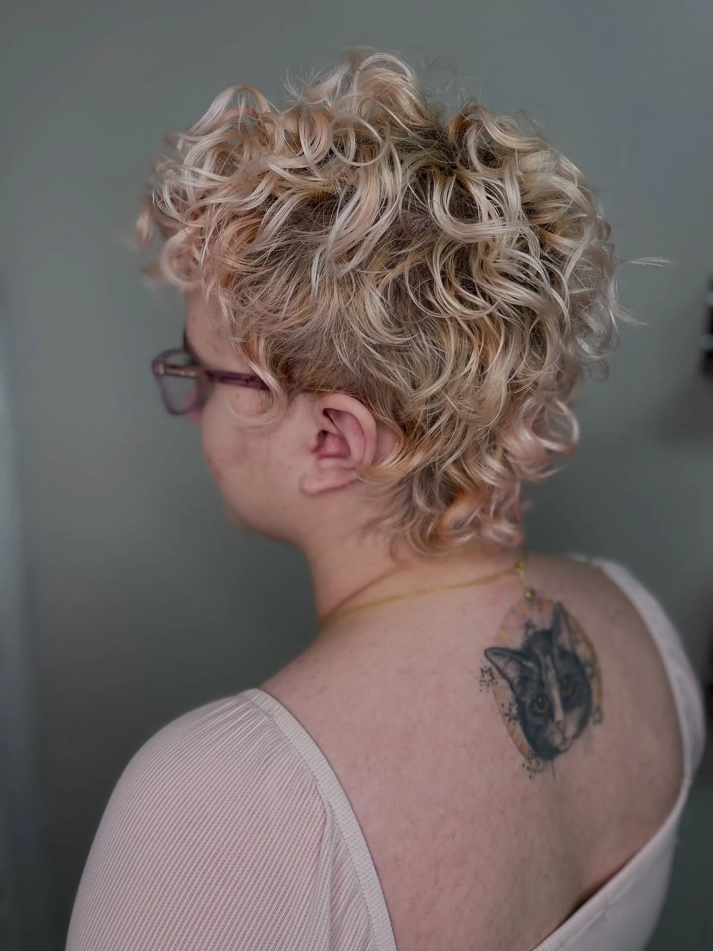 Blonde curly bixie with stacked curls and tapered nape
