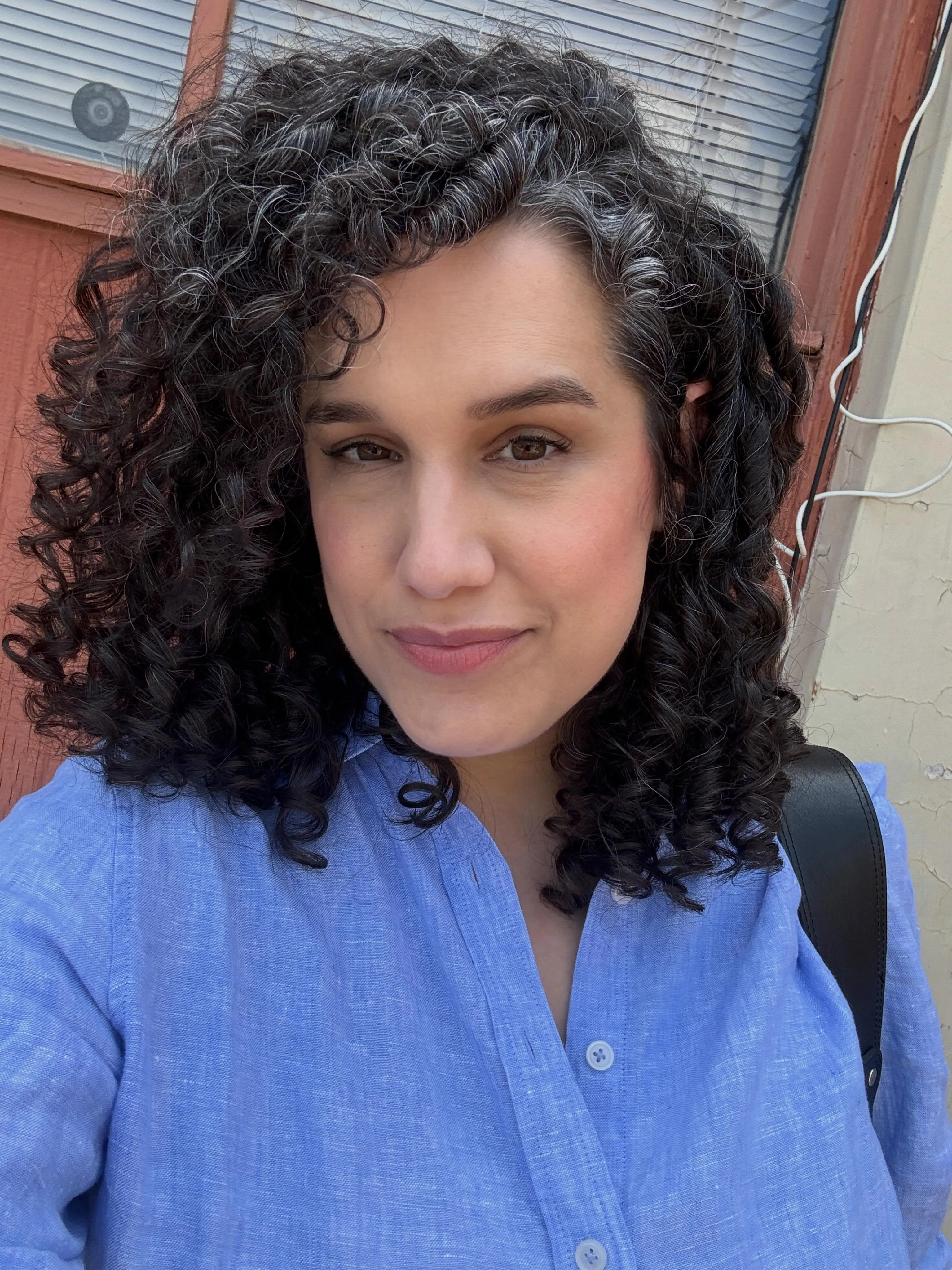 Dark side-parted curly lob with defined ringlets