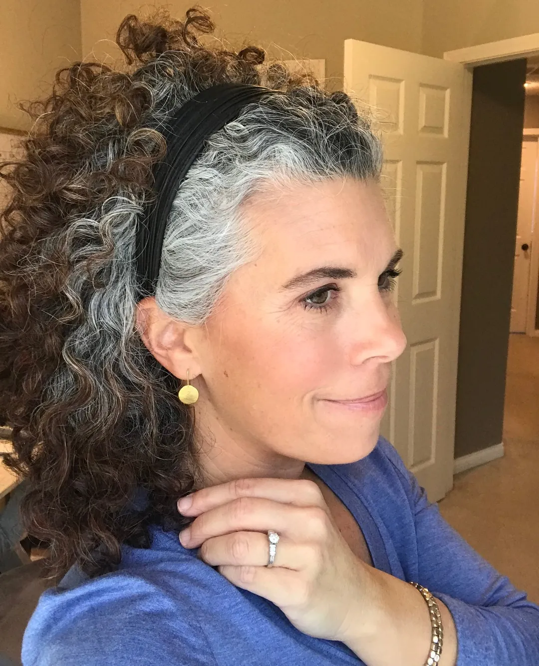 Long salt-and-pepper curls held back with a wide headband
