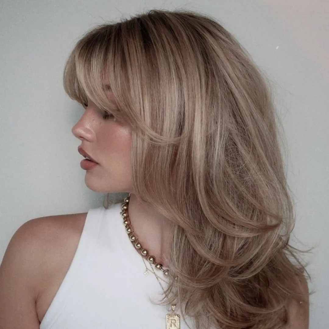 Long blonde curve cut with swooping layered blowout