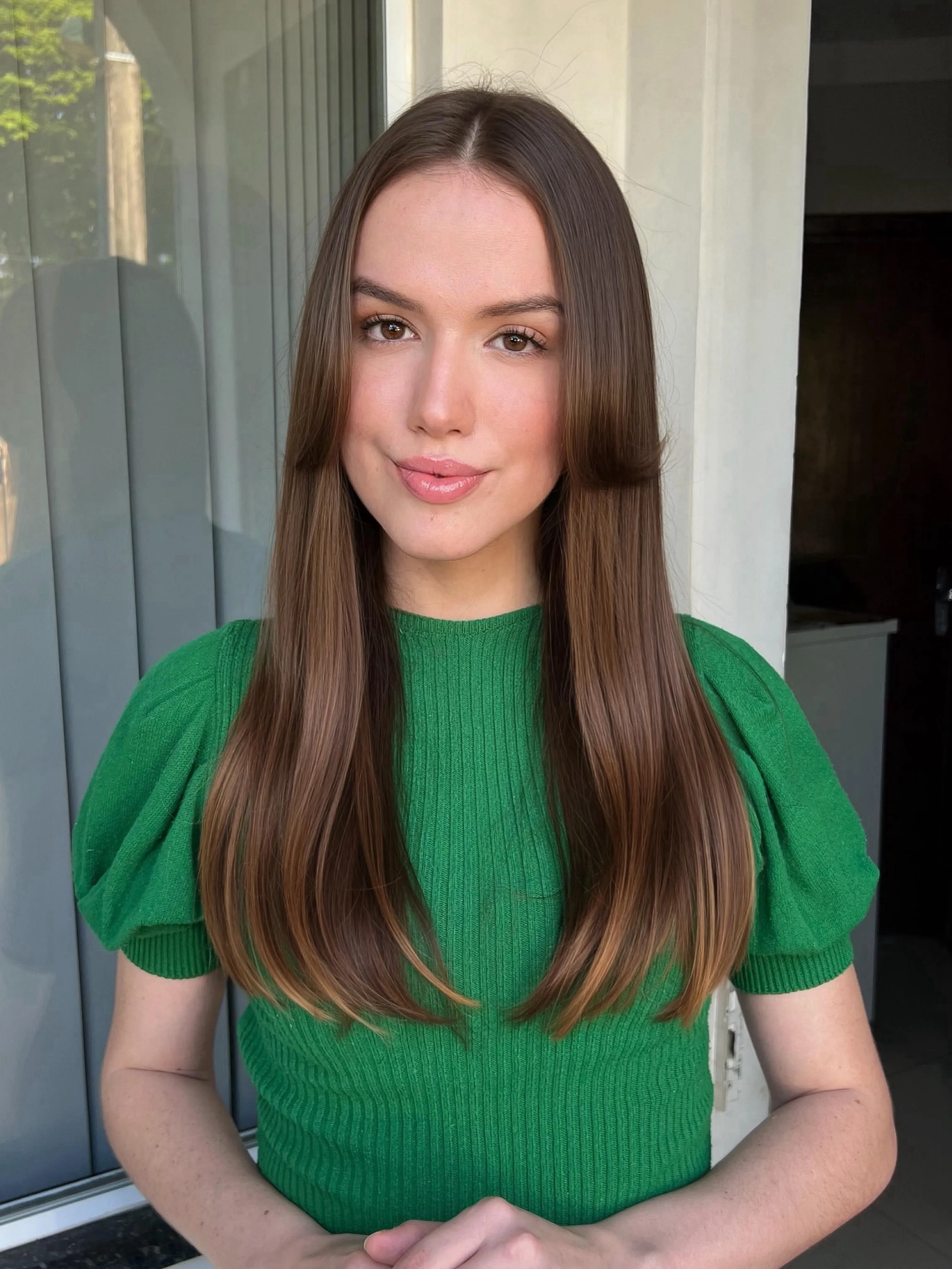 Long brown straight hair with rounded face-framing pieces and center part