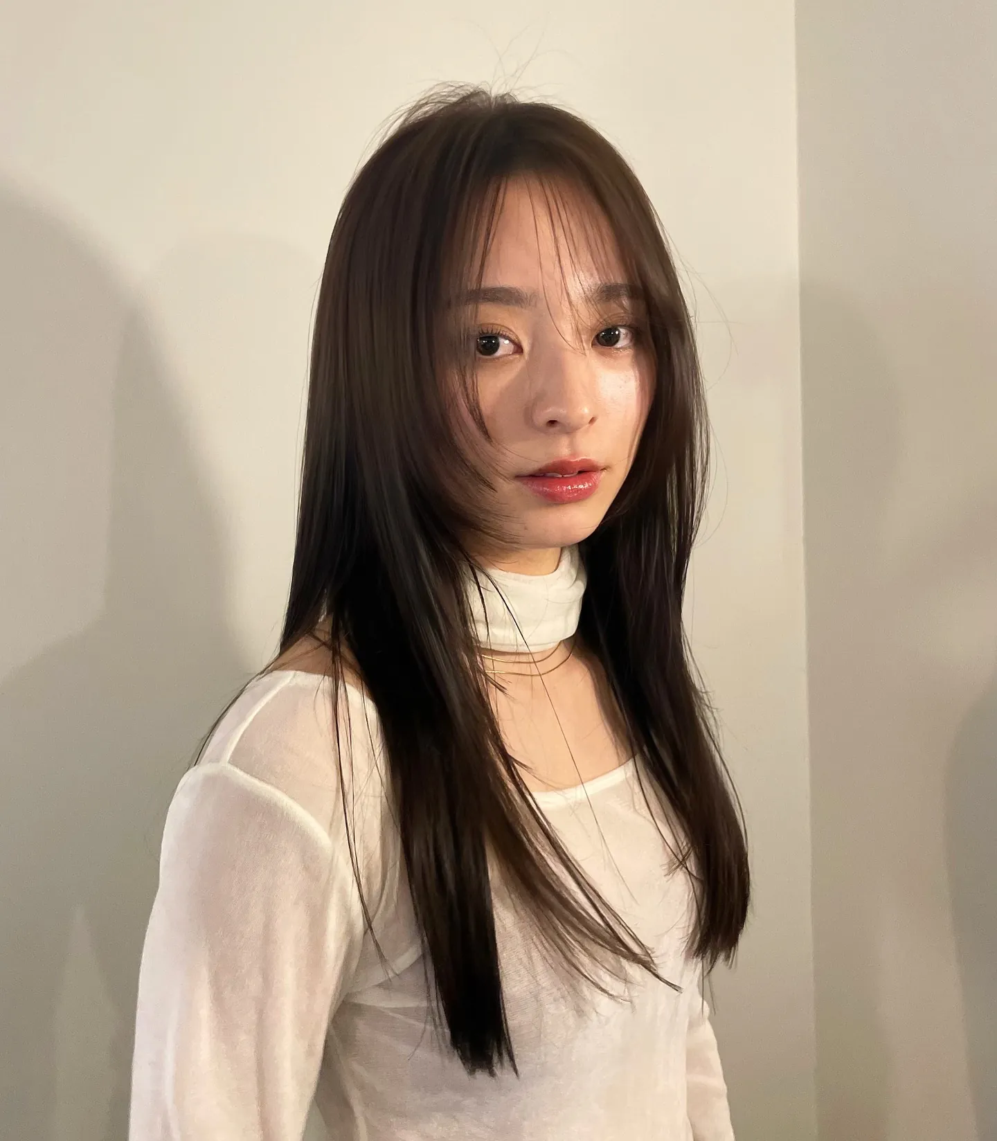 Long dark straight hair with wispy curtain fringe and face-framing layers