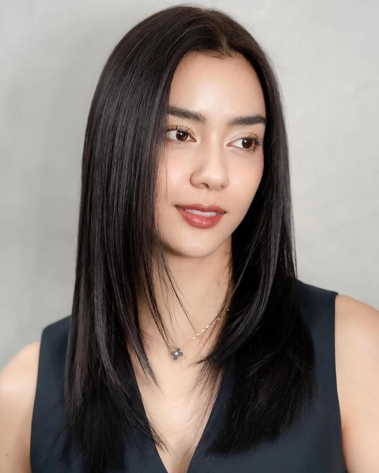 Dark straight hair with center part and sleek face-framing layers