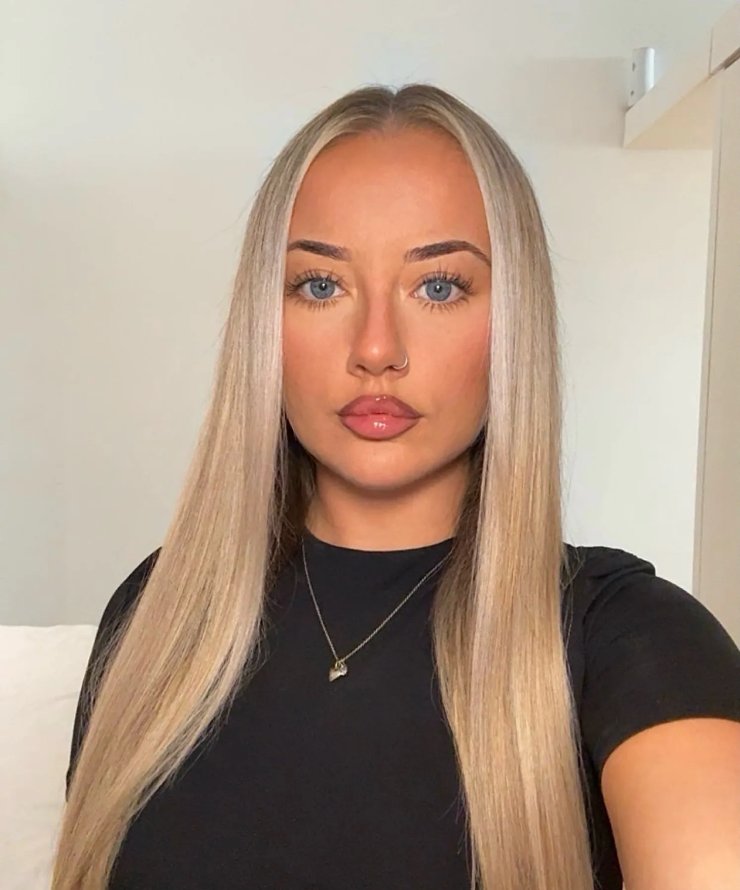 Long blonde straight hair with a center part and even lengths